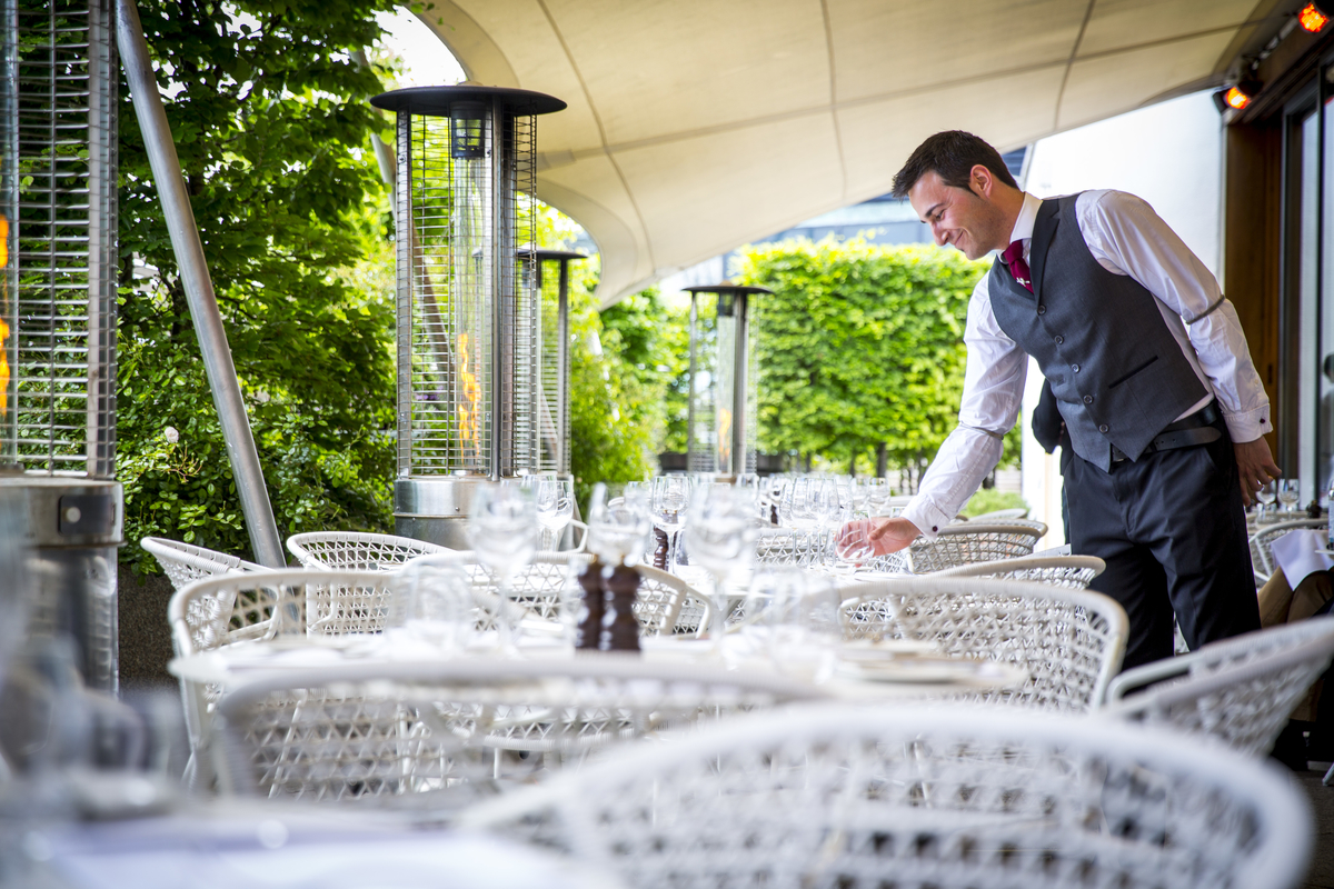 Bar Terrace at Coq d'Argent: elegant outdoor dining for upscale events with heaters and greenery.
