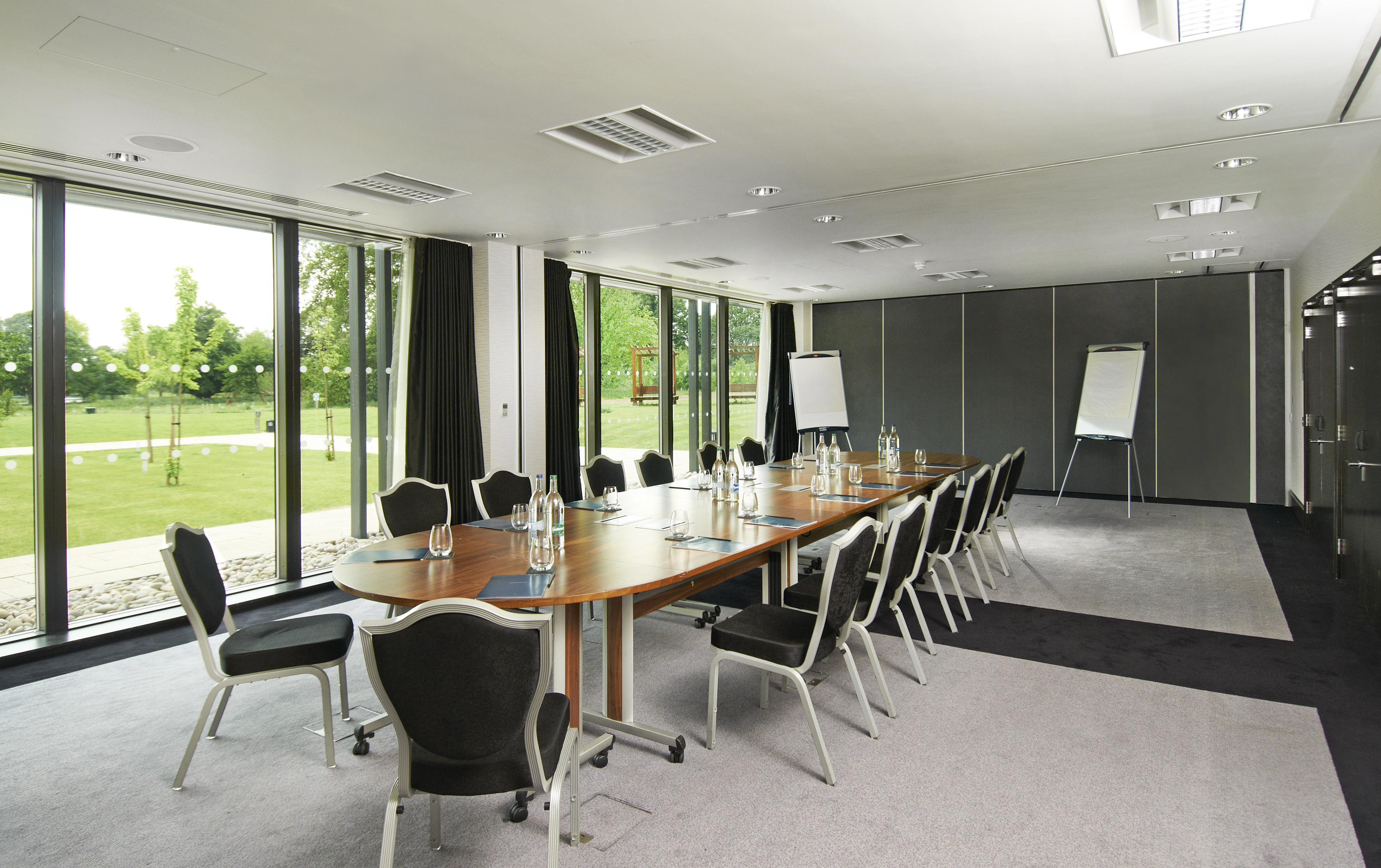Modern meeting room at Hilton London Syon Park with oval table, ideal for conferences.