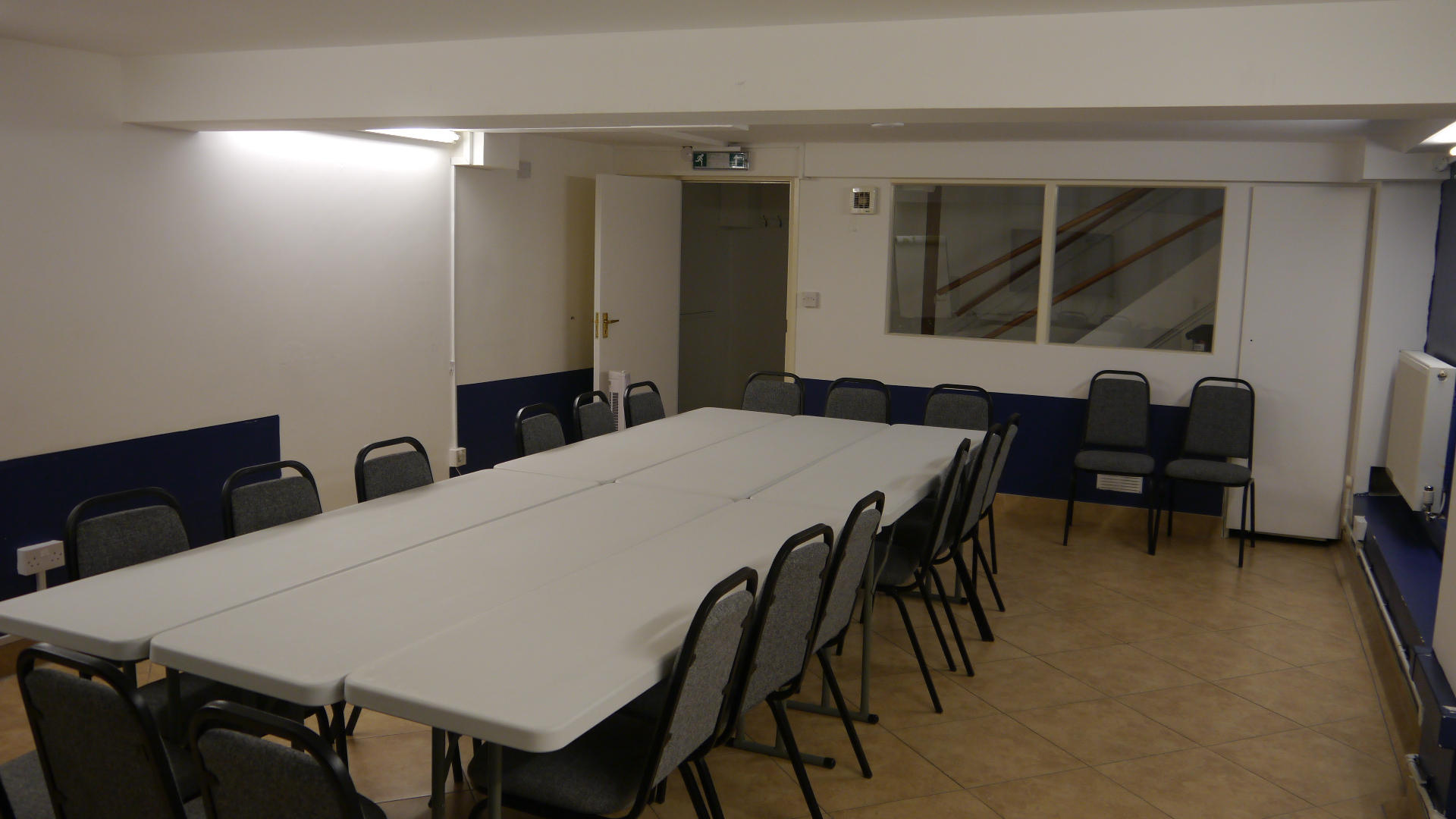Meeting room with long table and chairs, ideal for workshops and conferences.