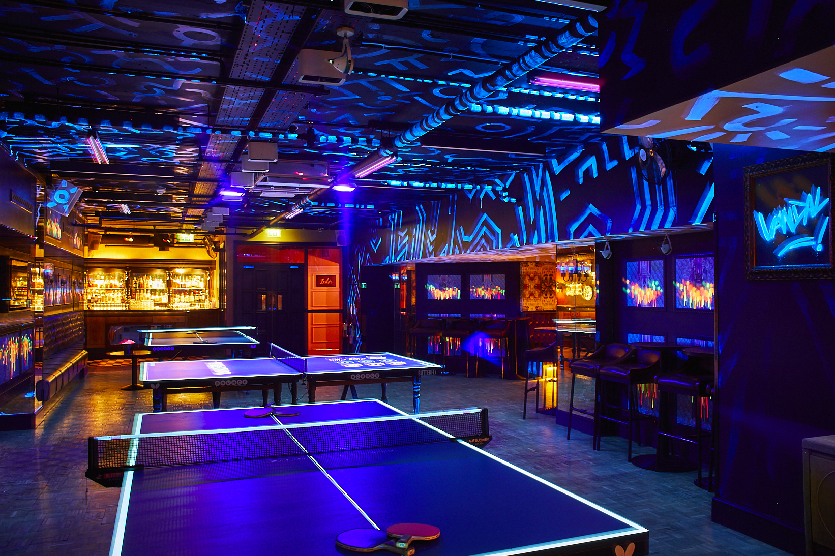 Vibrant Jaques Room with illuminated ping pong tables for events and gatherings.