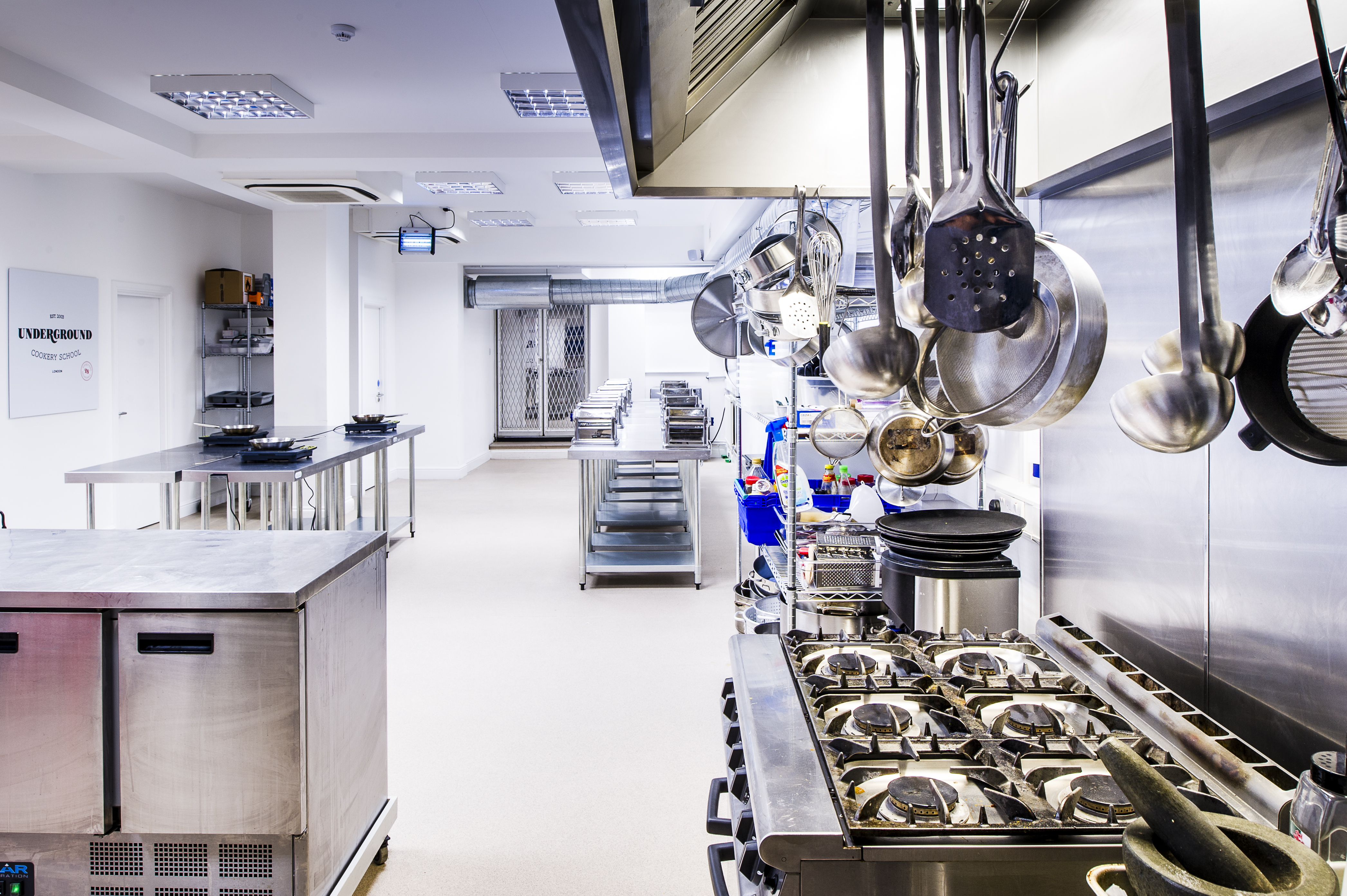 Modern kitchen venue for culinary events with stainless steel surfaces and ample space.