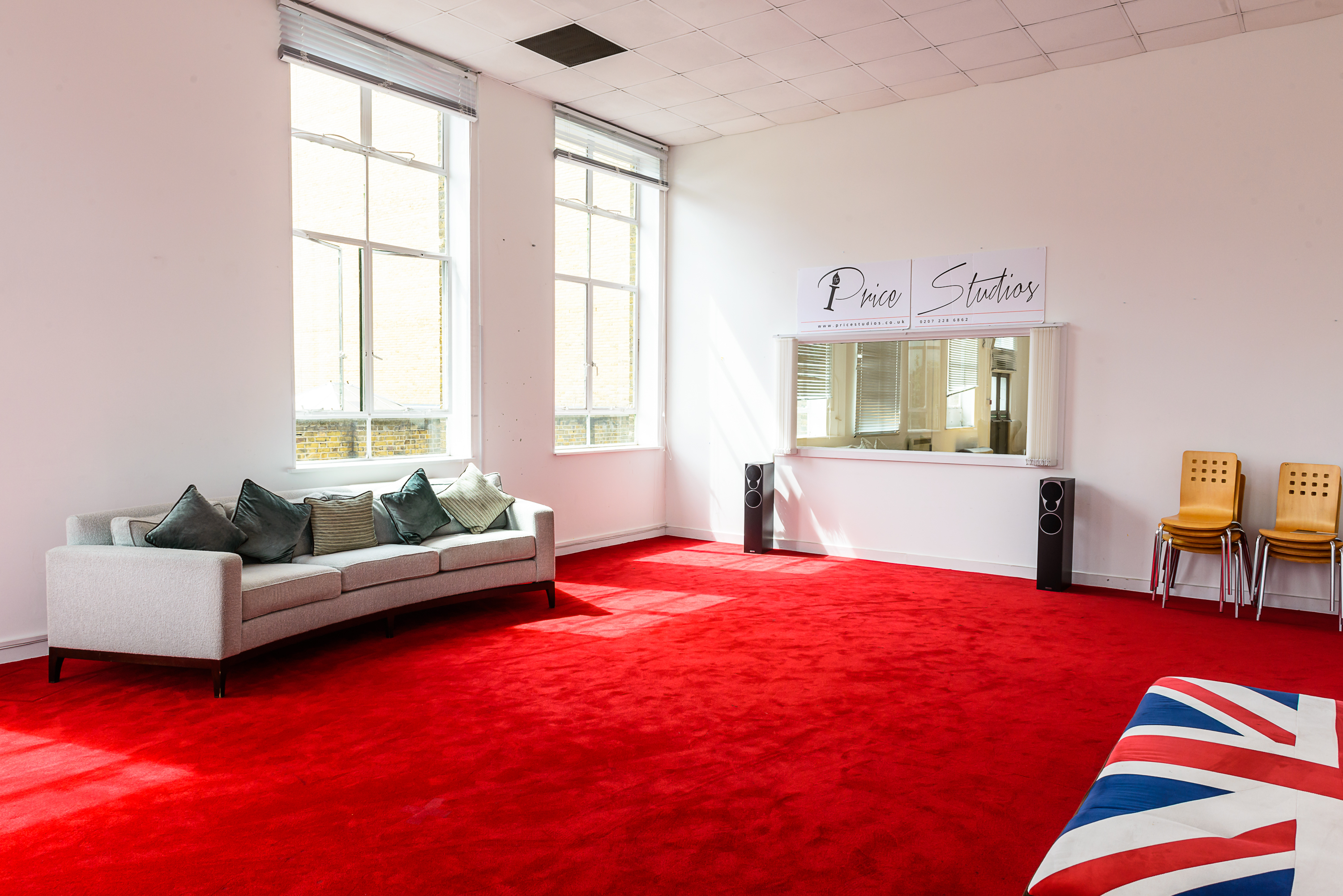 Spacious event space with red carpet, ideal for creative meetings and gatherings.
