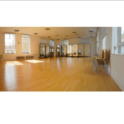 Spacious Studio 1 with polished floors, ideal for workshops and fitness classes.