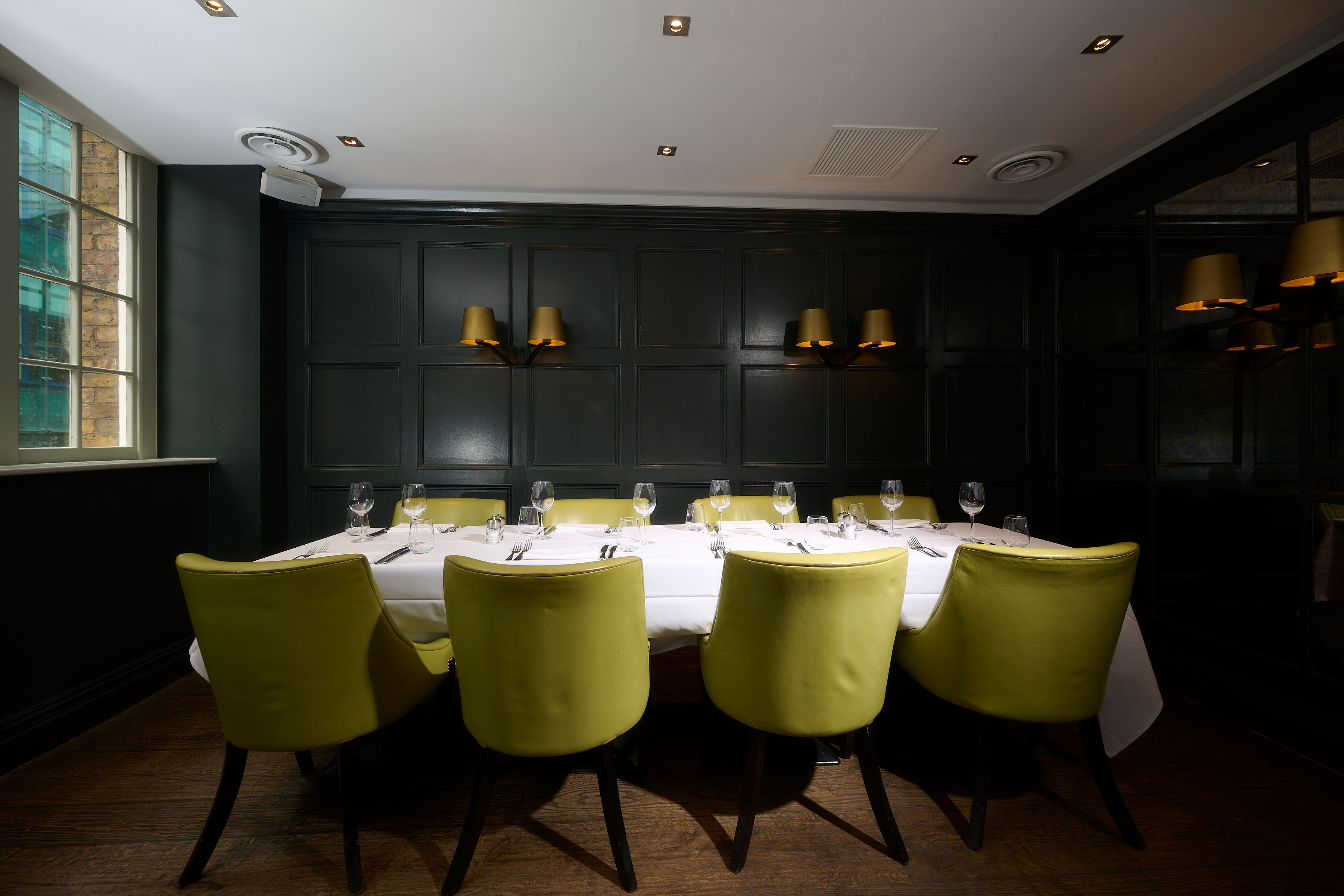 Stylish dining space with green chairs, ideal for private meetings and networking events.