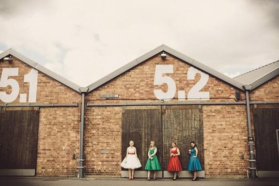 Group of women in vibrant dresses at rustic Paintworks Event Space for creative gatherings.