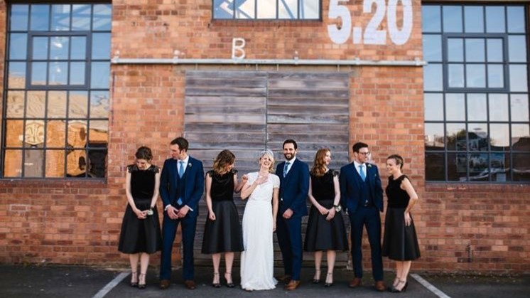 Stylish wedding party at rustic brick Paintworks Event Space, blending elegance and charm.