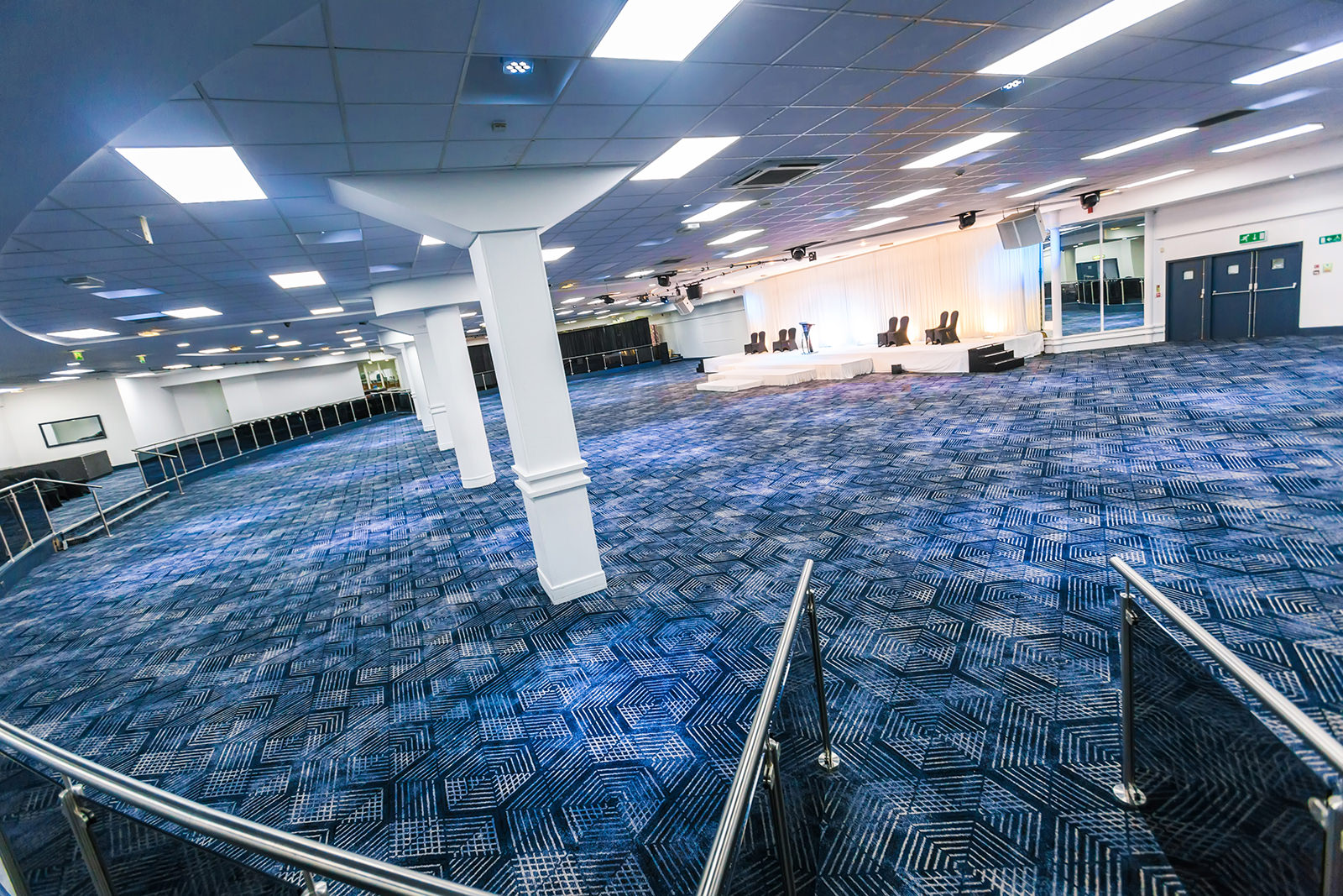 Spacious modern event space with carpeted area for conferences and exhibitions.