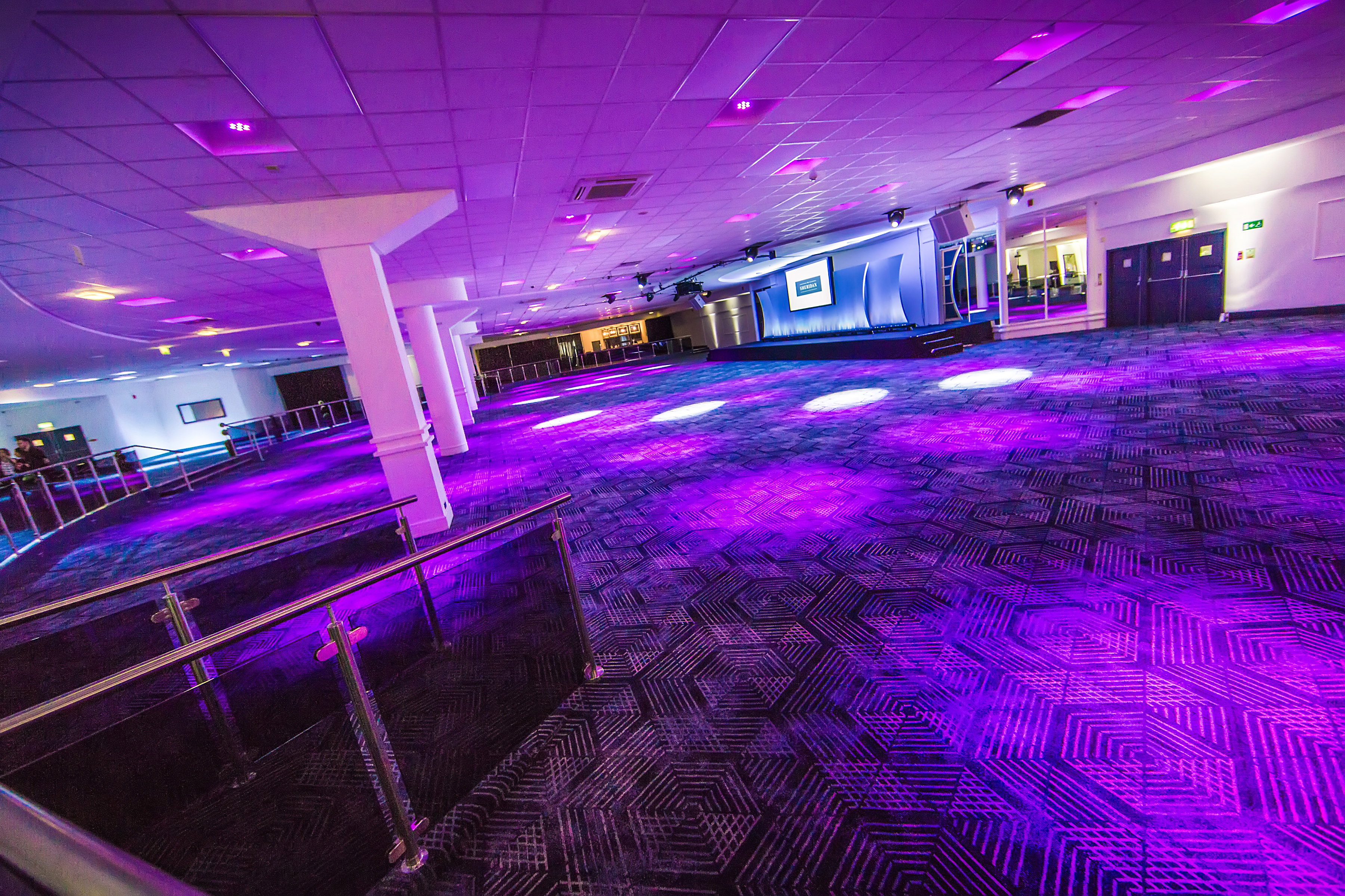 Spacious event venue with modern lighting, perfect for corporate meetings and social gatherings.