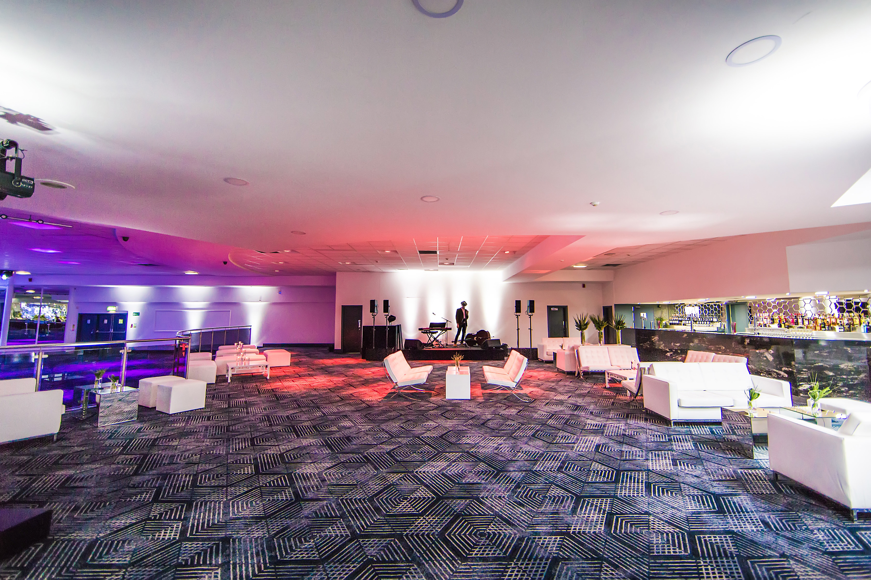 Spacious event venue with modern furnishings, ideal for networking and social gatherings.