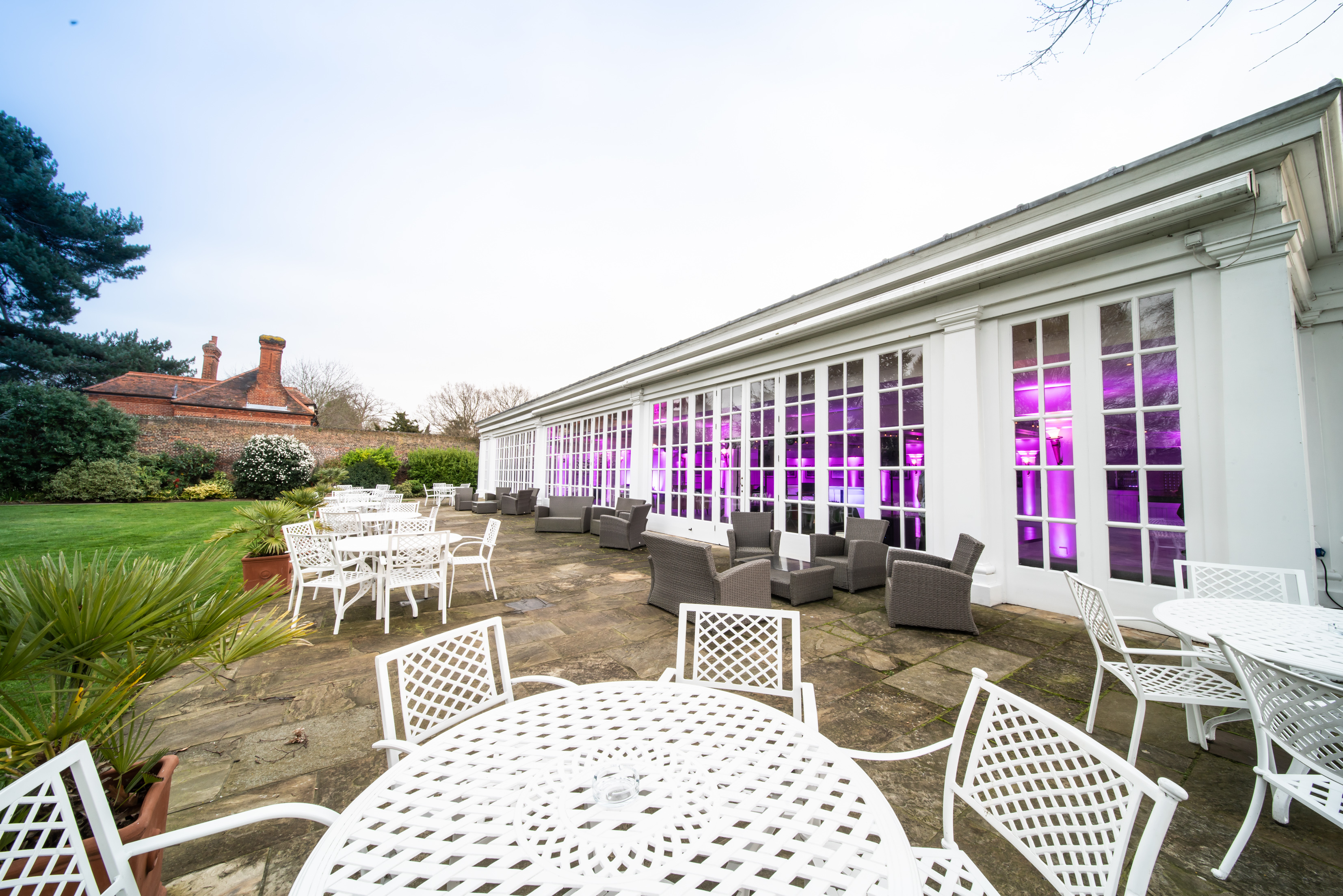 Stylish outdoor event space at Hampton Court Palace with elegant seating and purple lighting.