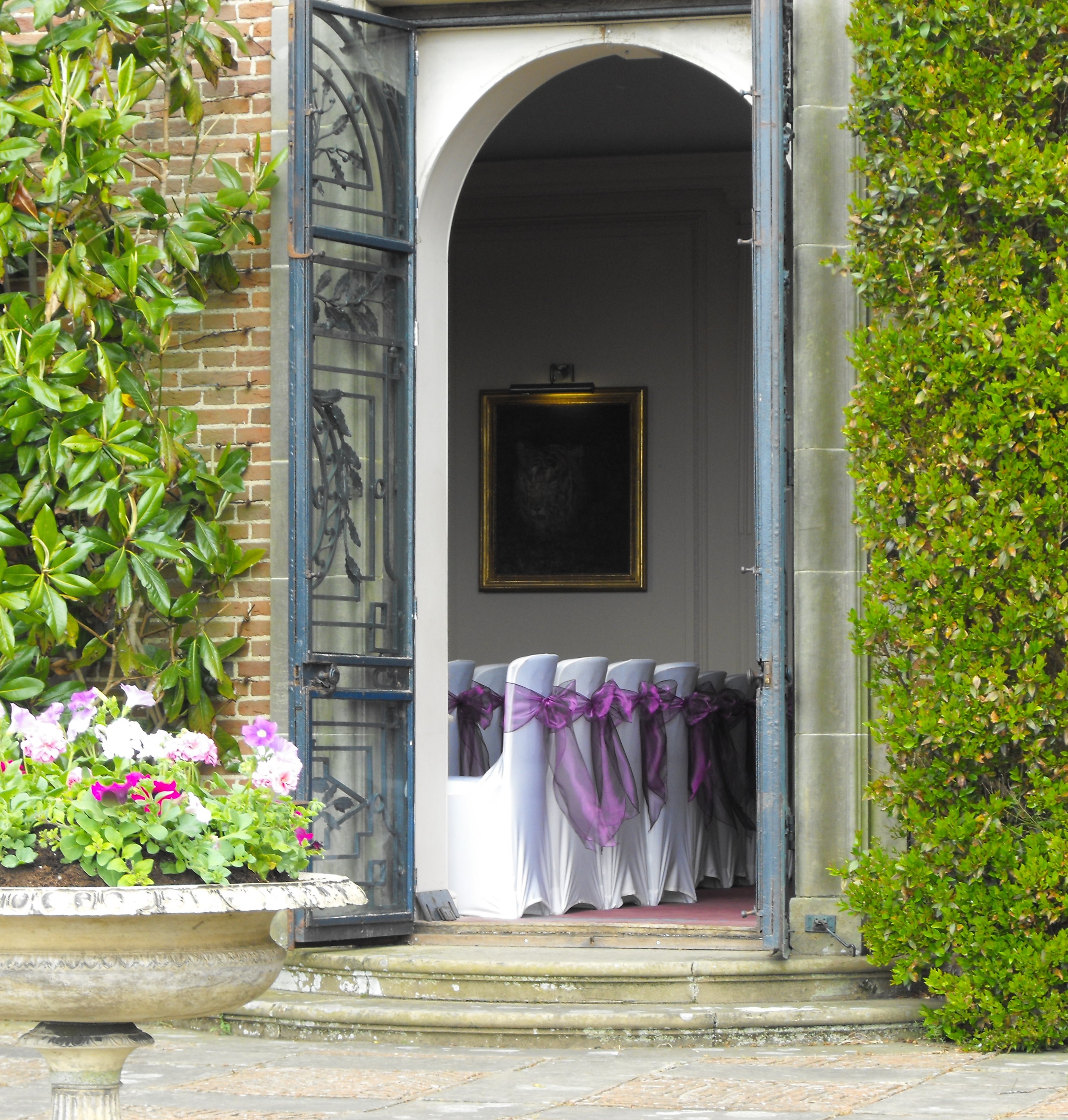 Elegant event space at Port Lympne Hotel with purple-sashed chairs, ideal for weddings.