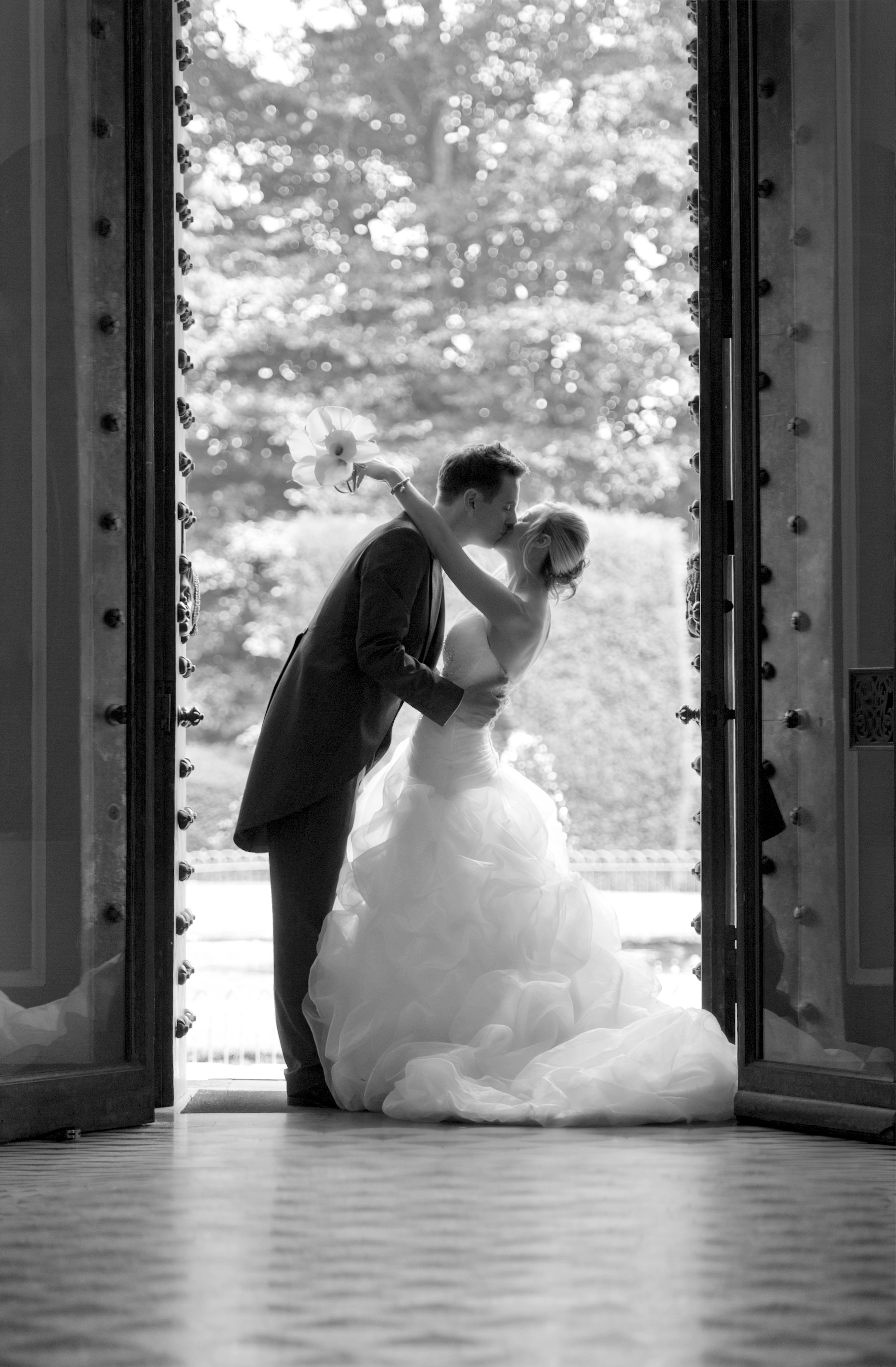 Romantic couple framed by elegant doorway at Port Lympne Hotel wedding venue.