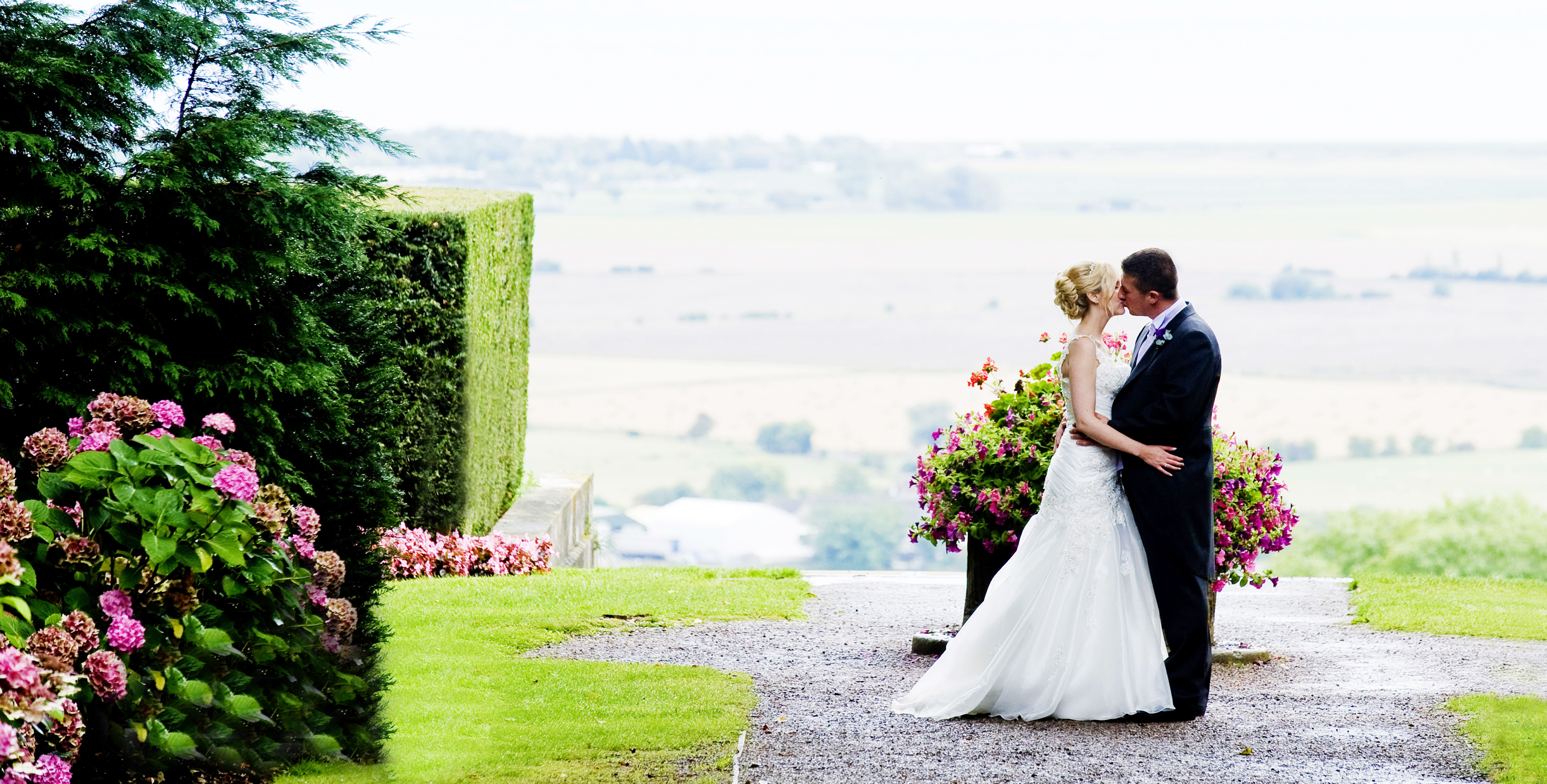 Outdoor wedding venue at Port Lympne Hotel with lush greenery and floral arrangements.