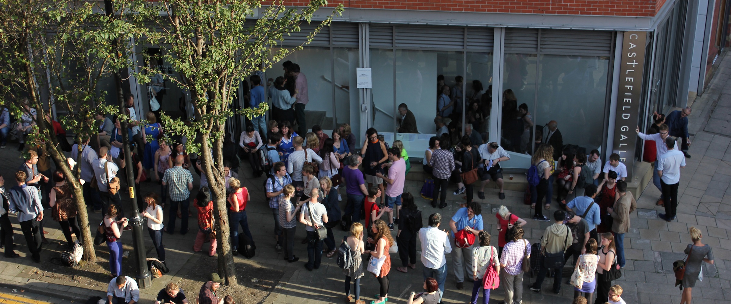 Outdoor conference at Castlefield Gallery with diverse attendees networking.