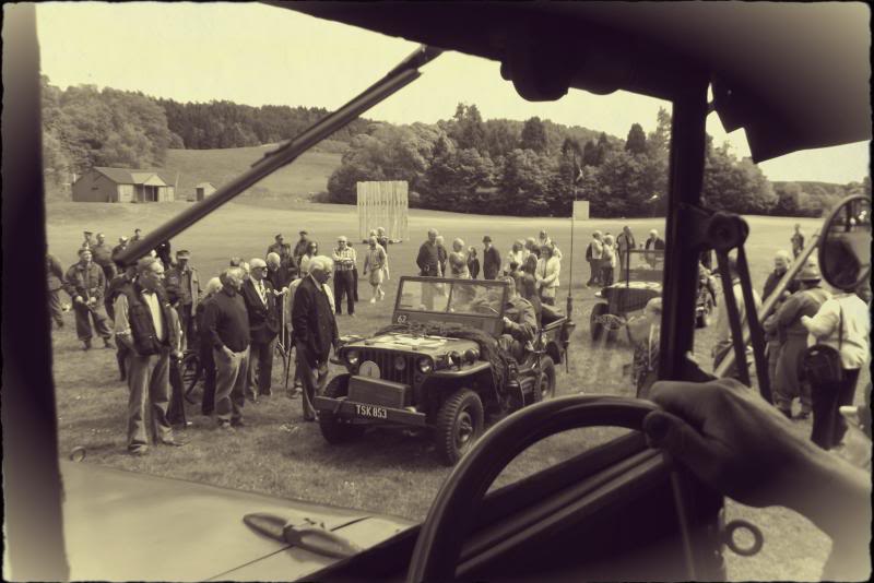 Outdoor event at Cultybraggan POW Camp with vintage vehicles and diverse crowd.