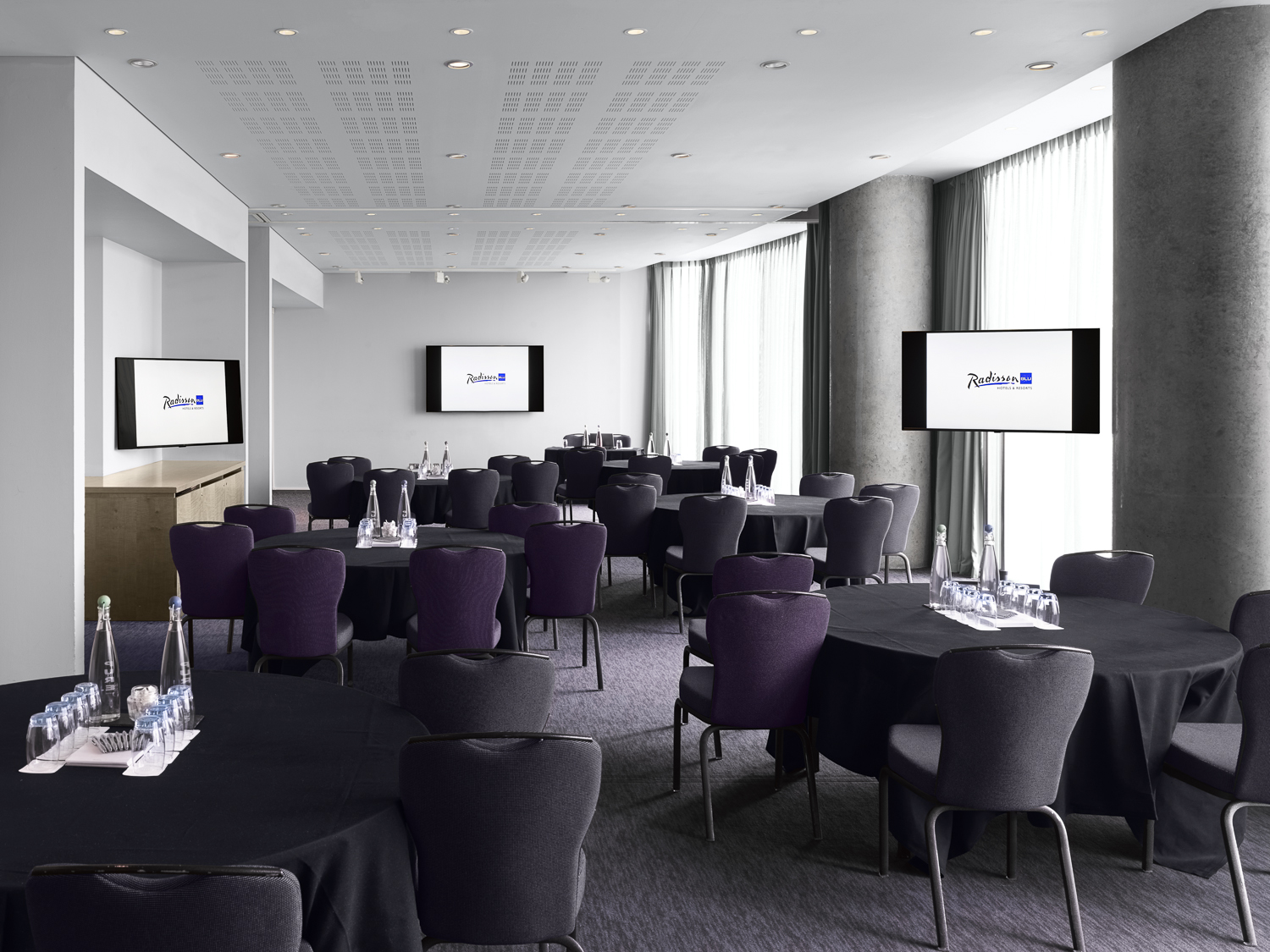 Dublin Suite at Radisson Blu: modern meeting space with round tables for corporate events.
