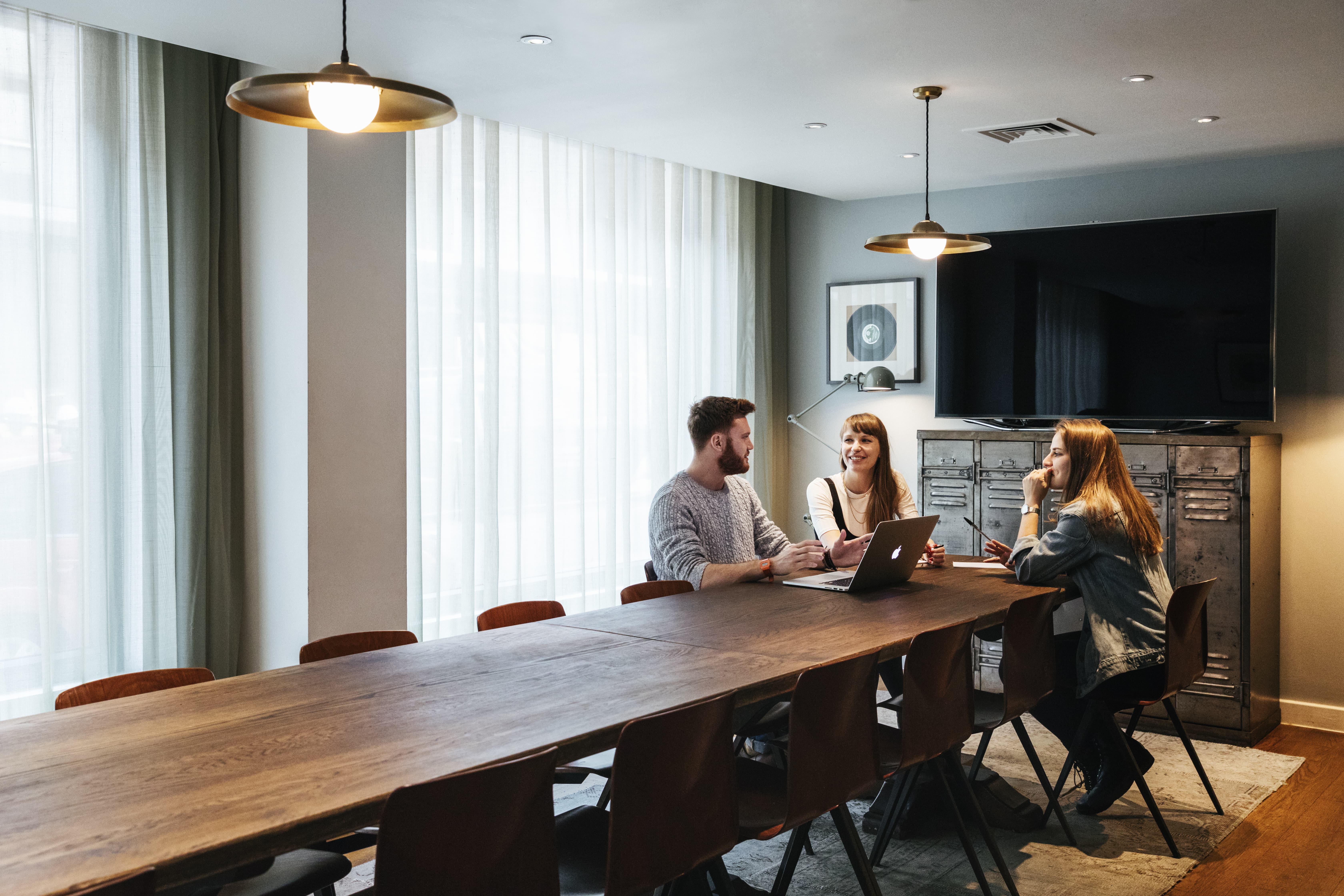 Modern meeting room with wooden table, ideal for team brainstorming sessions.