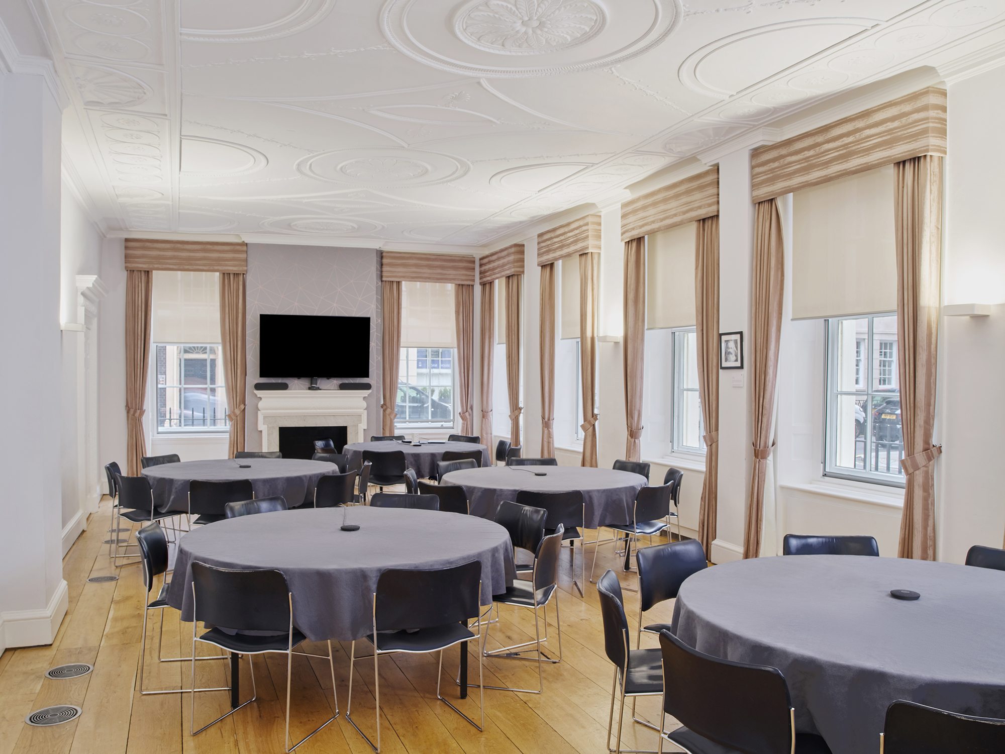 Tavern Room at RSA House: elegant meeting space with round tables for events and presentations.