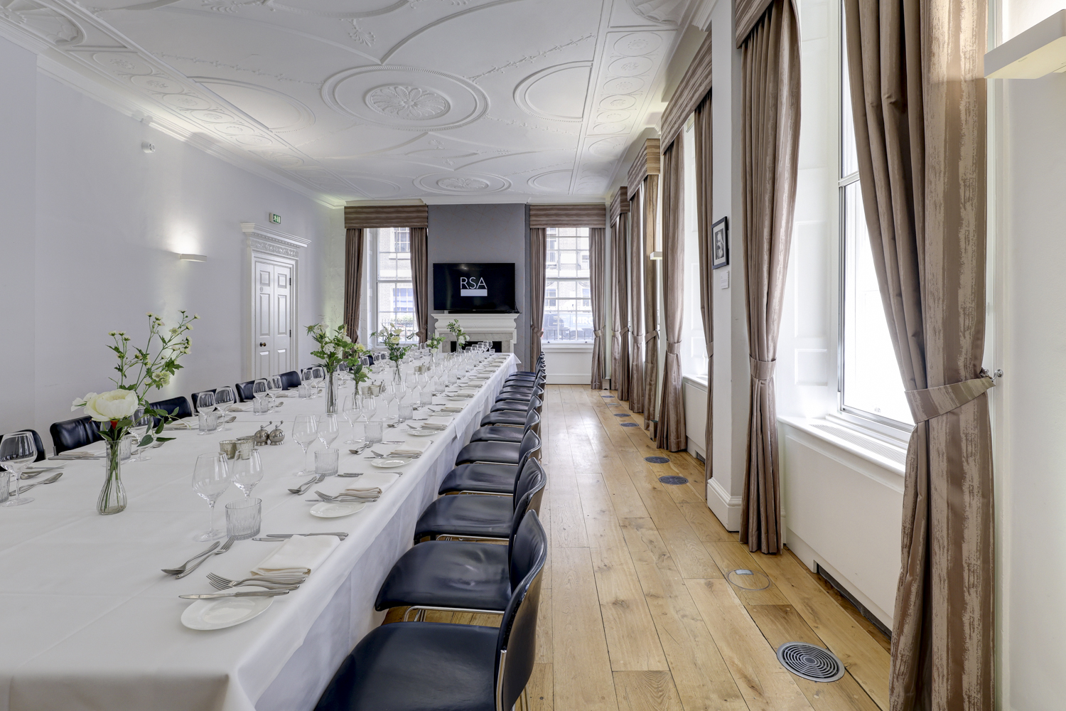 Elegant meeting room with floral centerpieces, perfect for events and gatherings.