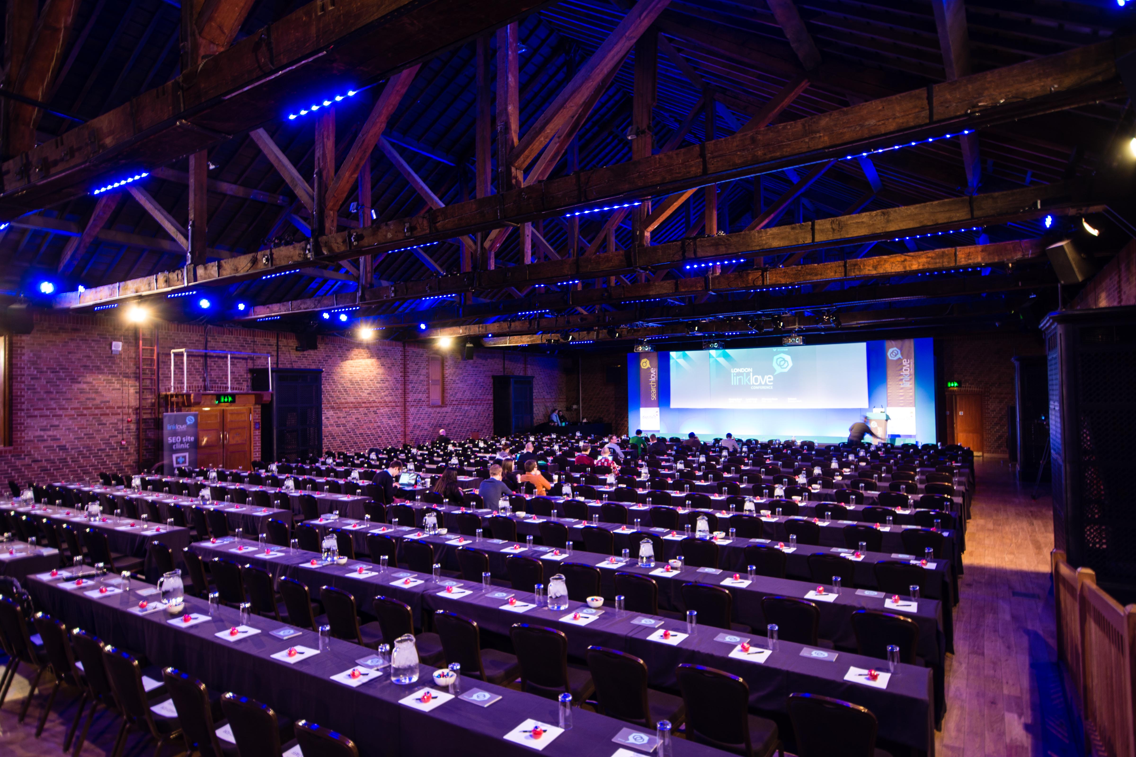 Conference setup at The Porter Tun with rows of tables and a large presentation screen.
