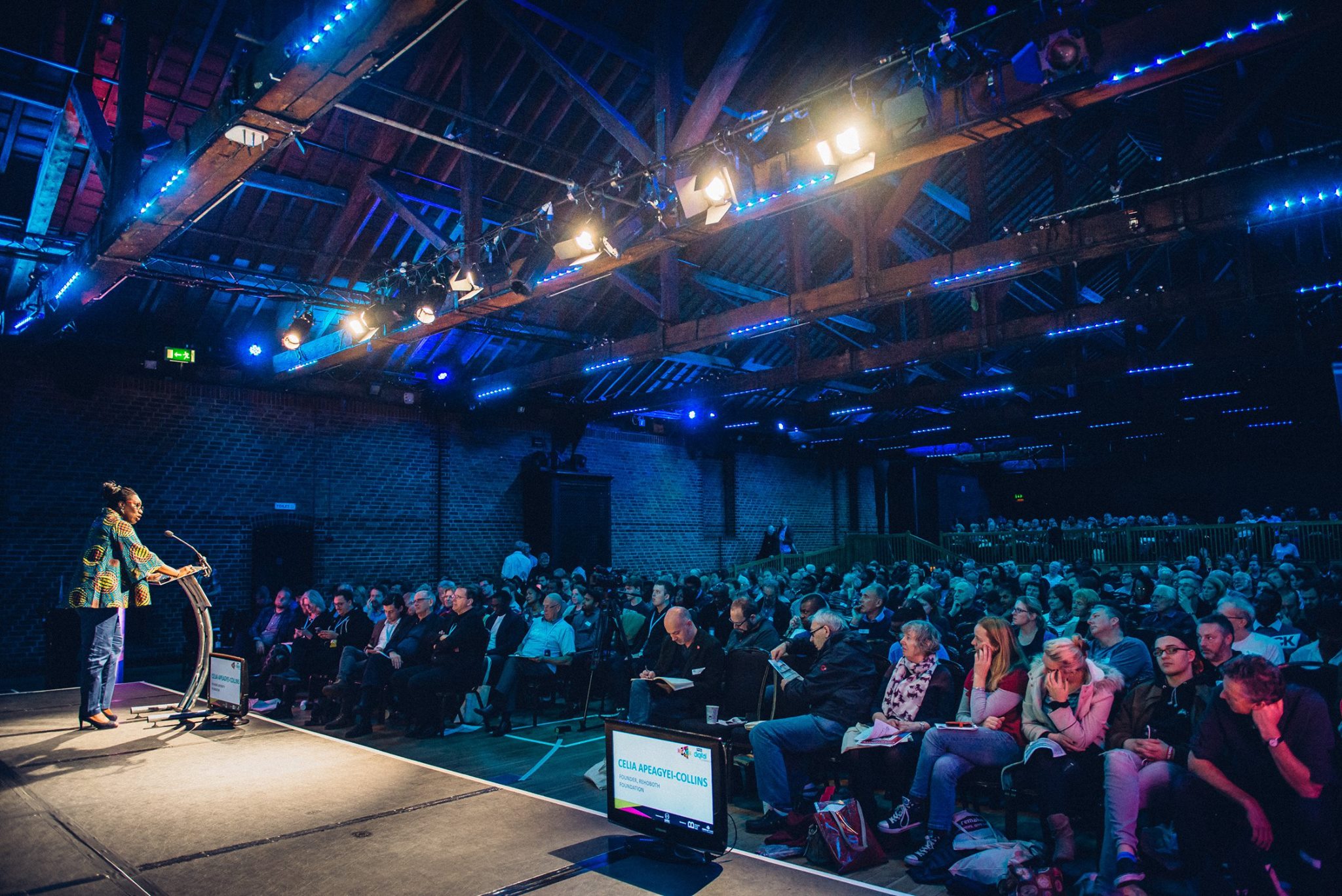 Engaging speaker at The Porter Tun conference with attentive audience in a spacious venue.