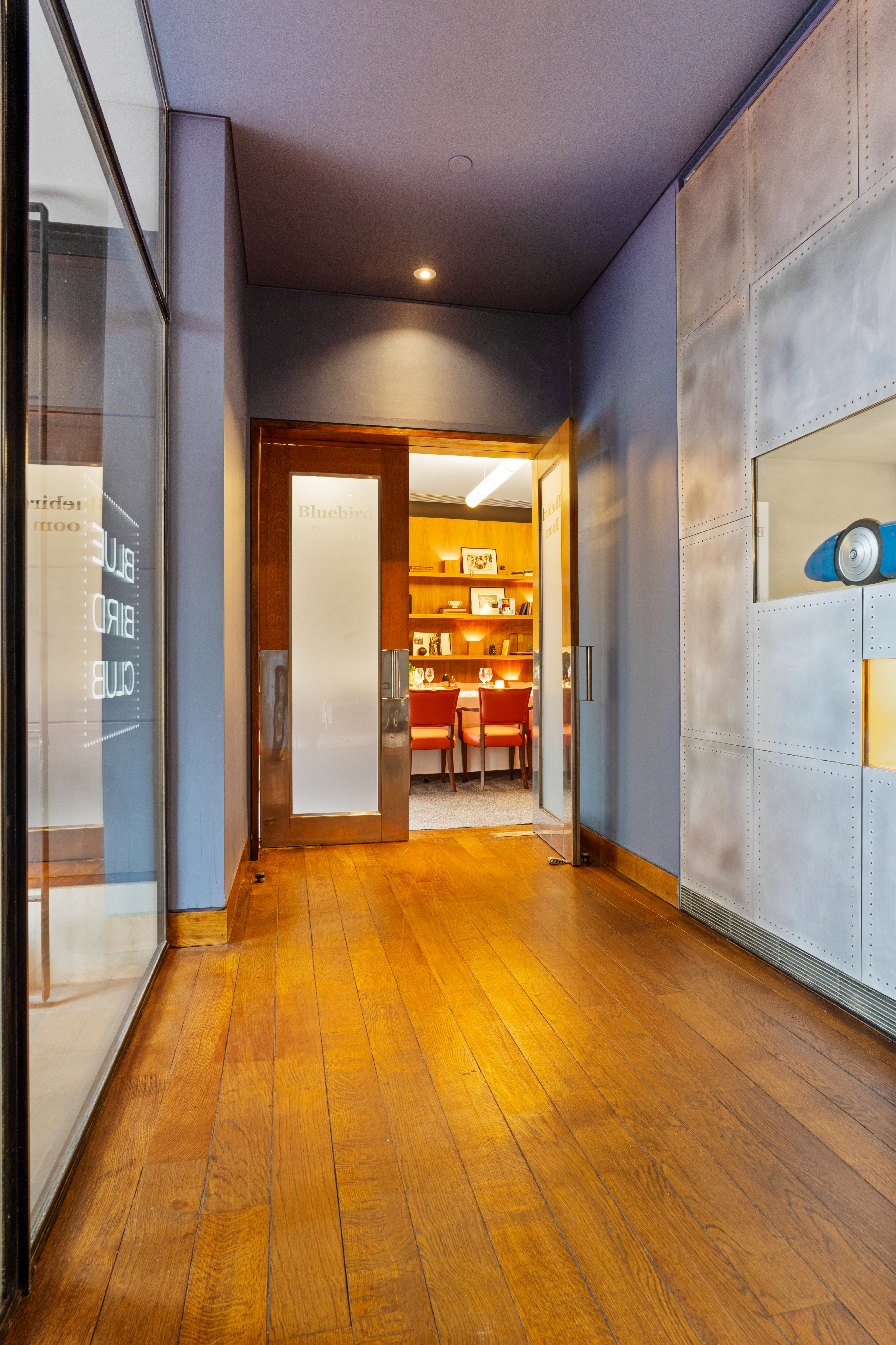 Bluebird Room entrance with glass doors, modern design for meetings and presentations.