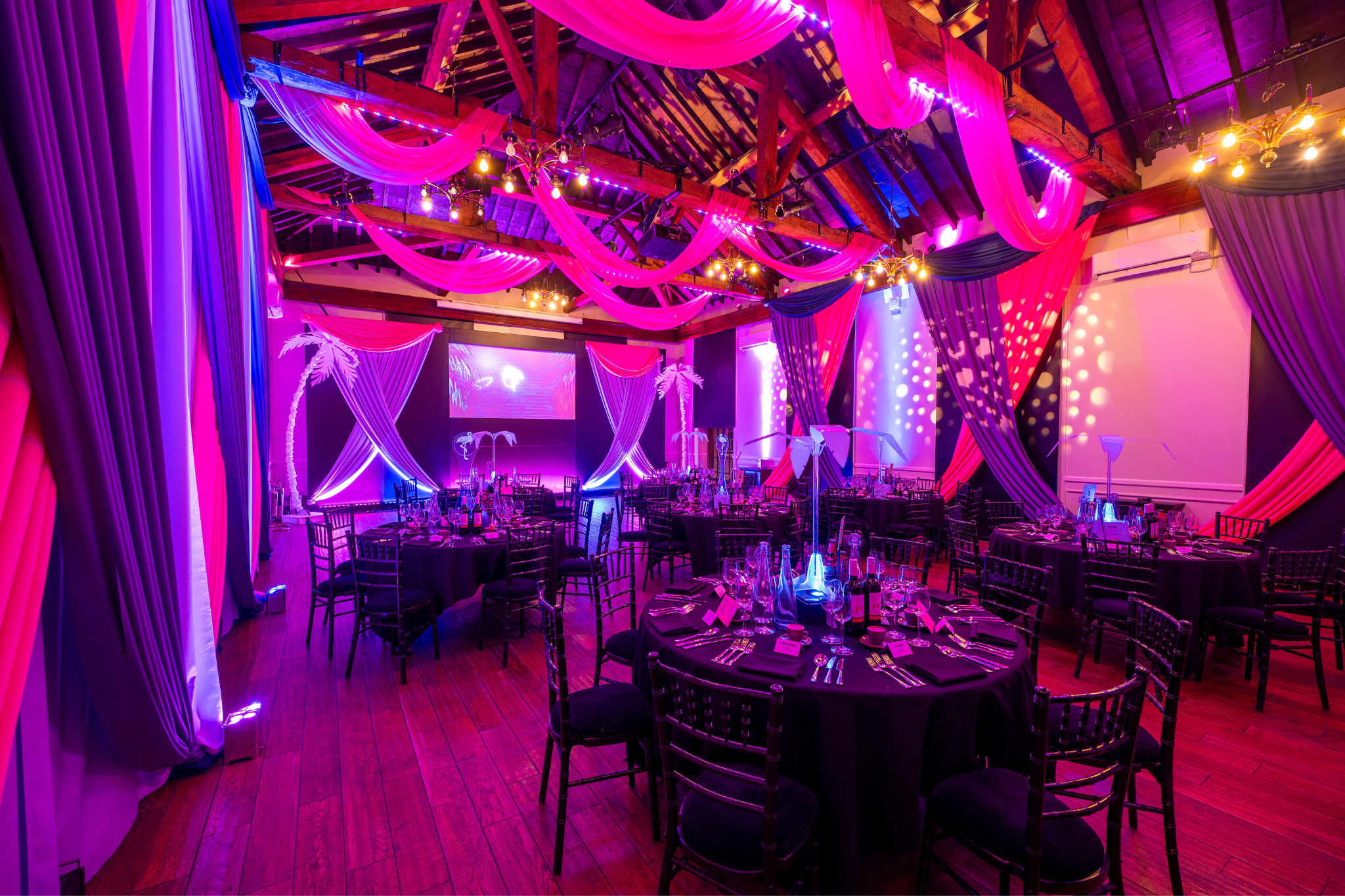 Elegant gala event space with bold drapery and dynamic lighting at The Sugar Rooms.