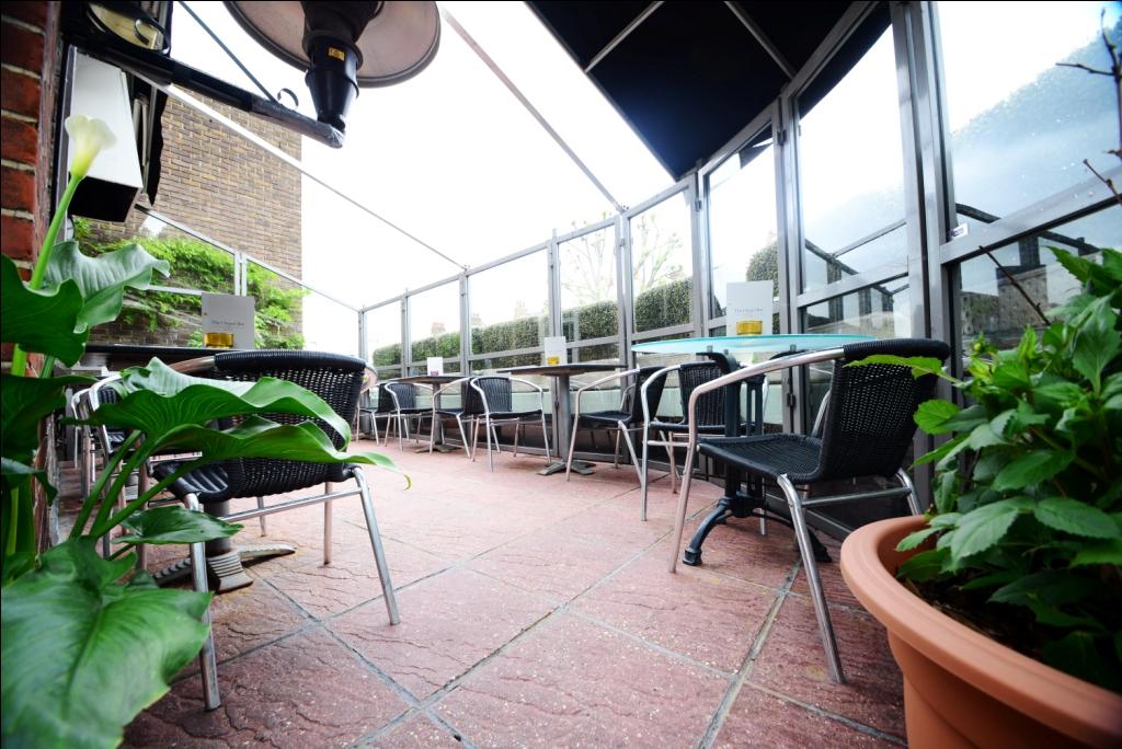 Outdoor event space with glass enclosure and flexible seating at The Terrace Room.