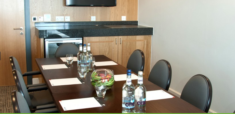 Executive Boxes at StoneX Stadium, modern meeting room with conference table, ideal for events.