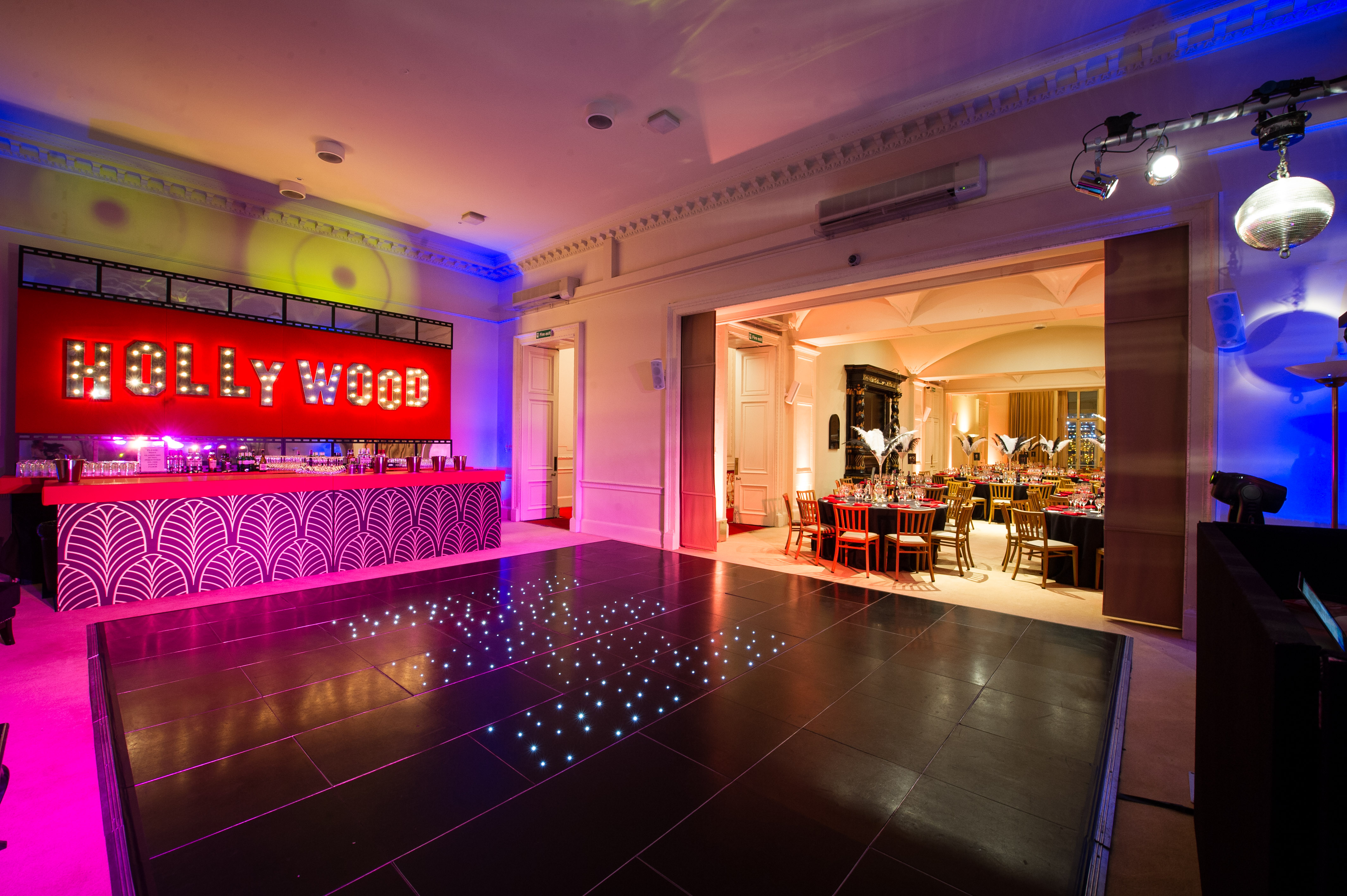 Hollywood-themed event space with illuminated sign and sleek dance floor in Kent House.