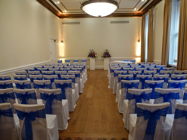 Elegant Rutland Room with blue-sashed chairs, perfect for formal events and ceremonies.