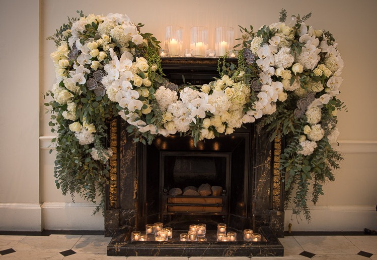 Floral display over fireplace in Marble Hall, Kent House for elegant weddings and events.