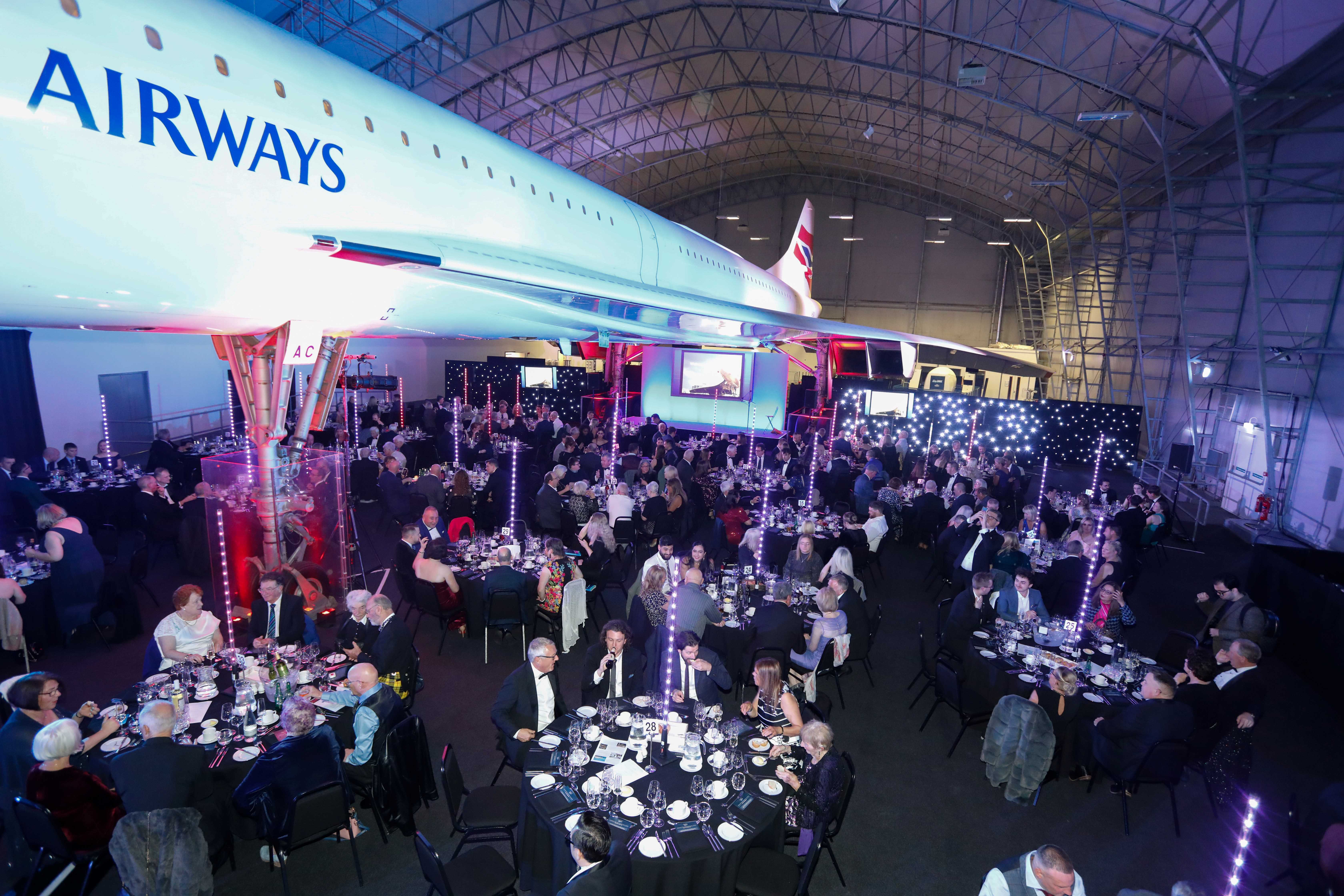 Concorde Hangar event space with suspended airplane, perfect for corporate gatherings.