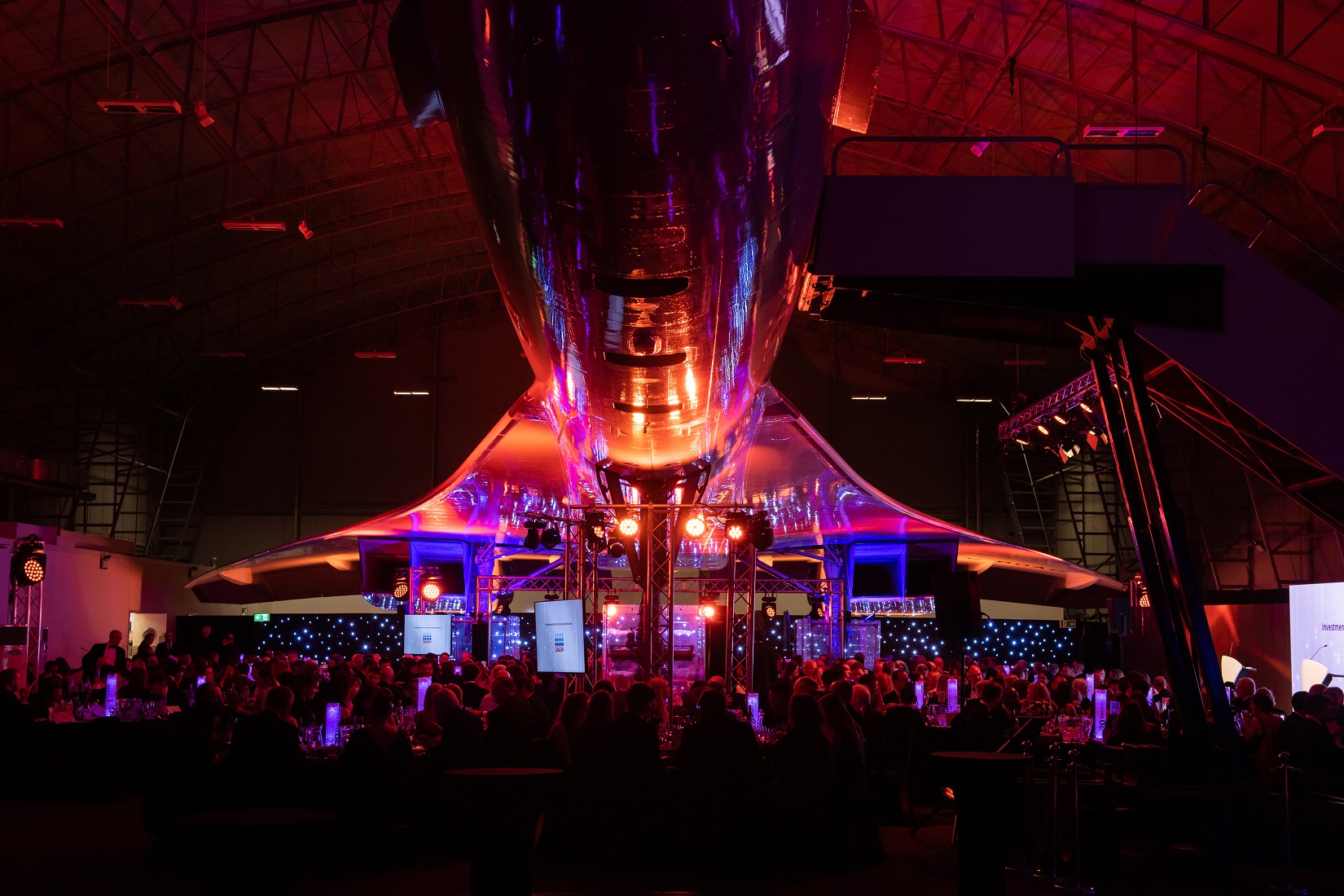 Concorde Hangar event space with dramatic lighting for corporate gatherings and celebrations.