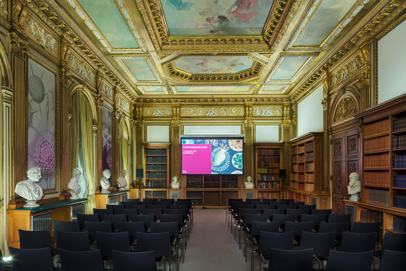 Elegant meeting space with large screen, ideal for conferences and lectures.