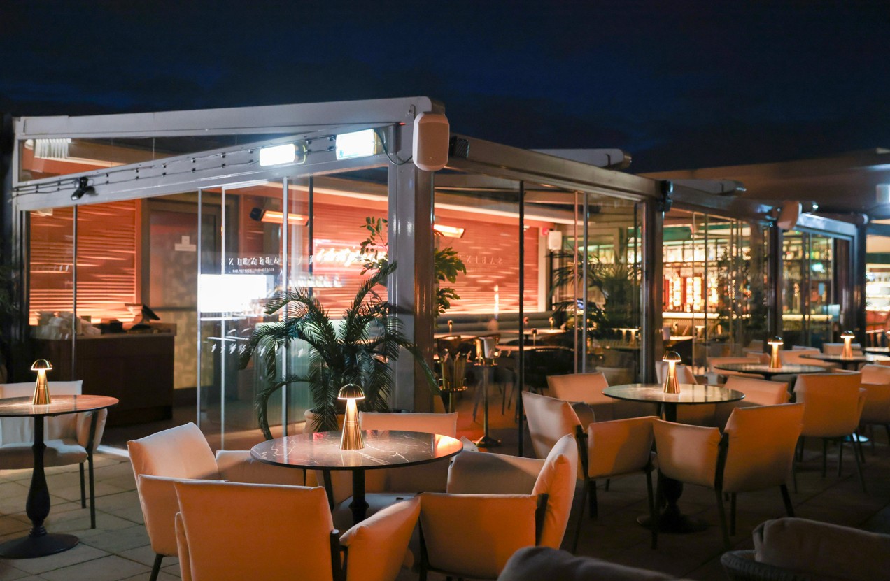 Sabine Rooftop Bar at Leonardo Royal Hotel: chic outdoor venue with modern glass structures.