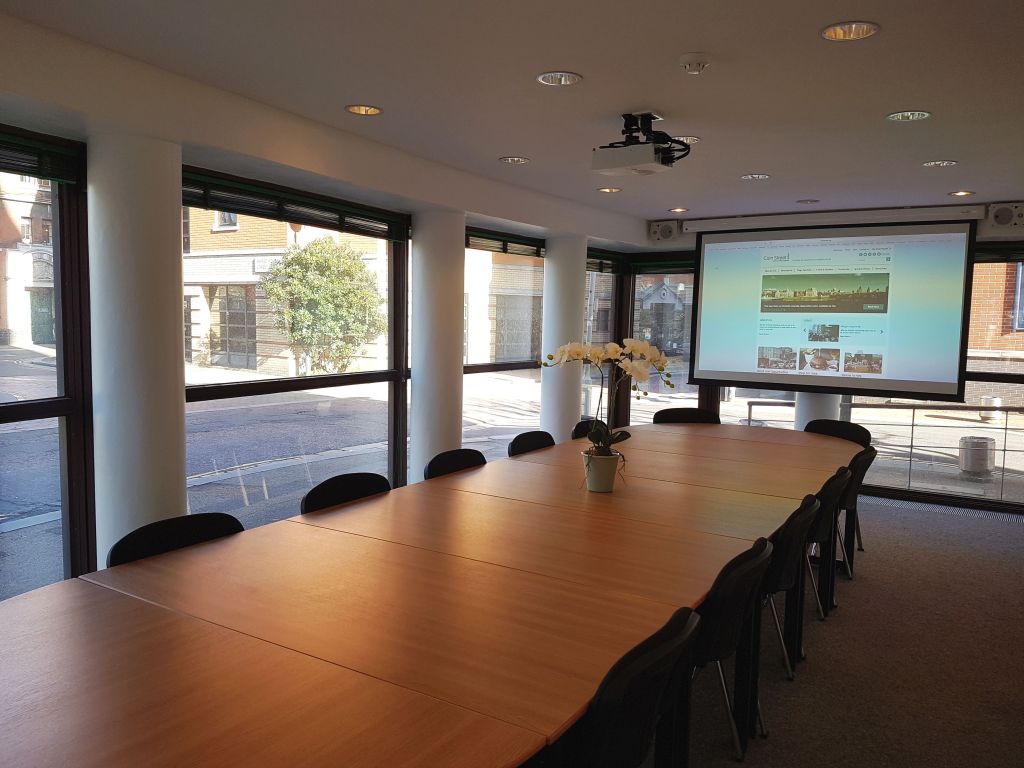 Palm Meeting Room with large wooden table, perfect for conferences and events.