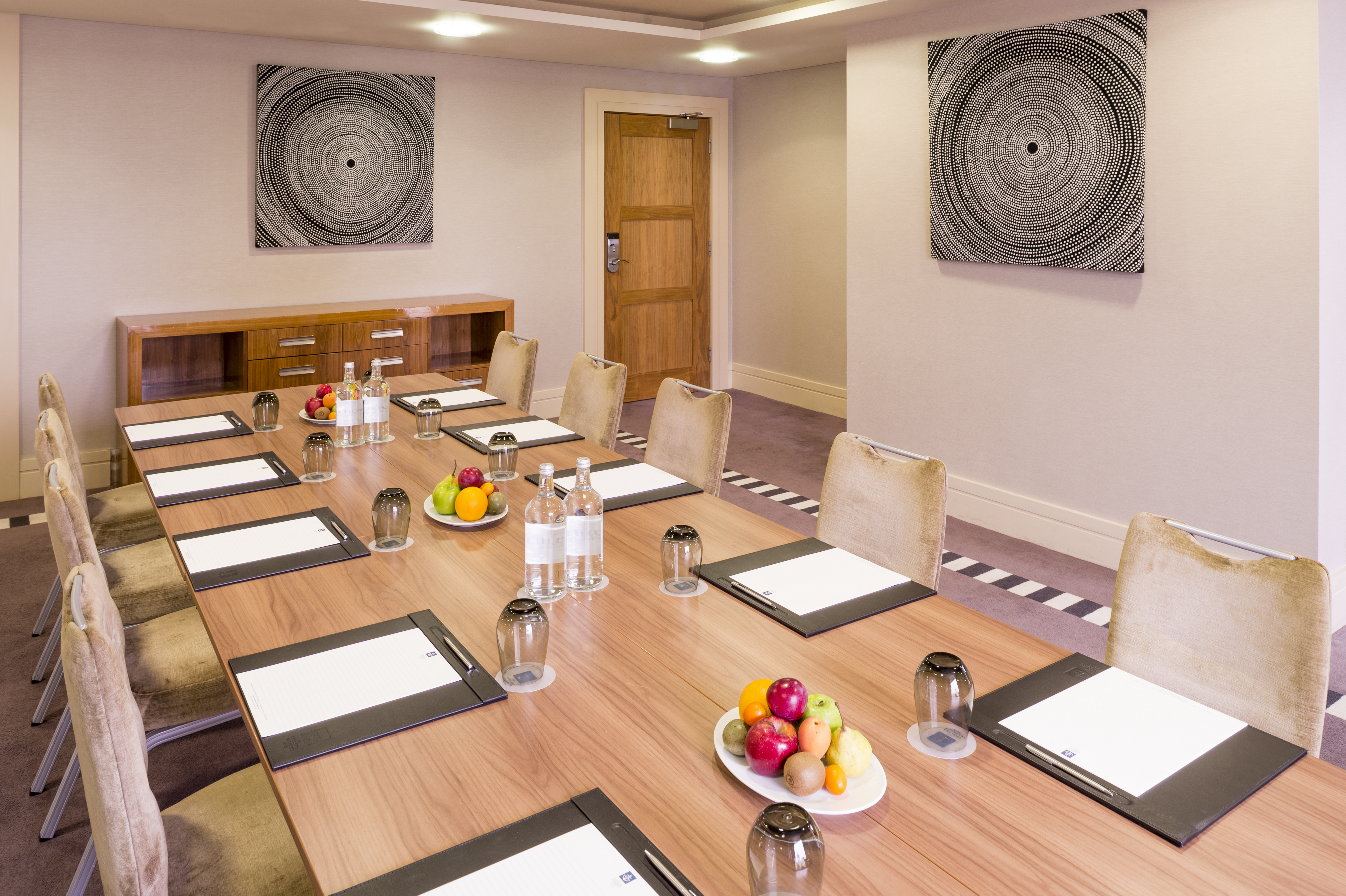 Albert Suite meeting room at Chelsea Harbour Hotel, featuring a long wooden table and natural light.