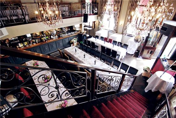 Elegant restaurant venue with chandeliers, perfect for corporate events and celebrations.