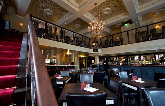 Elegant two-level restaurant with plush seating, ideal for upscale events or weddings.