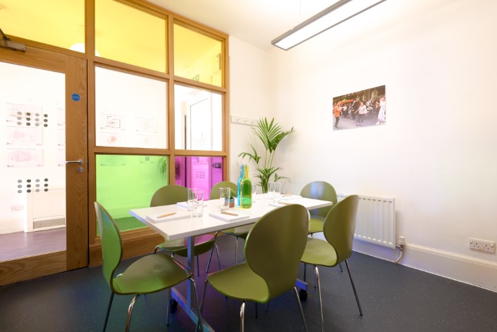 Modern meeting room with vibrant glass panels for creative gatherings in Fitzrovia.
