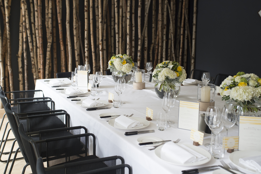 Elegant dining table with floral centerpieces for corporate events or gatherings.