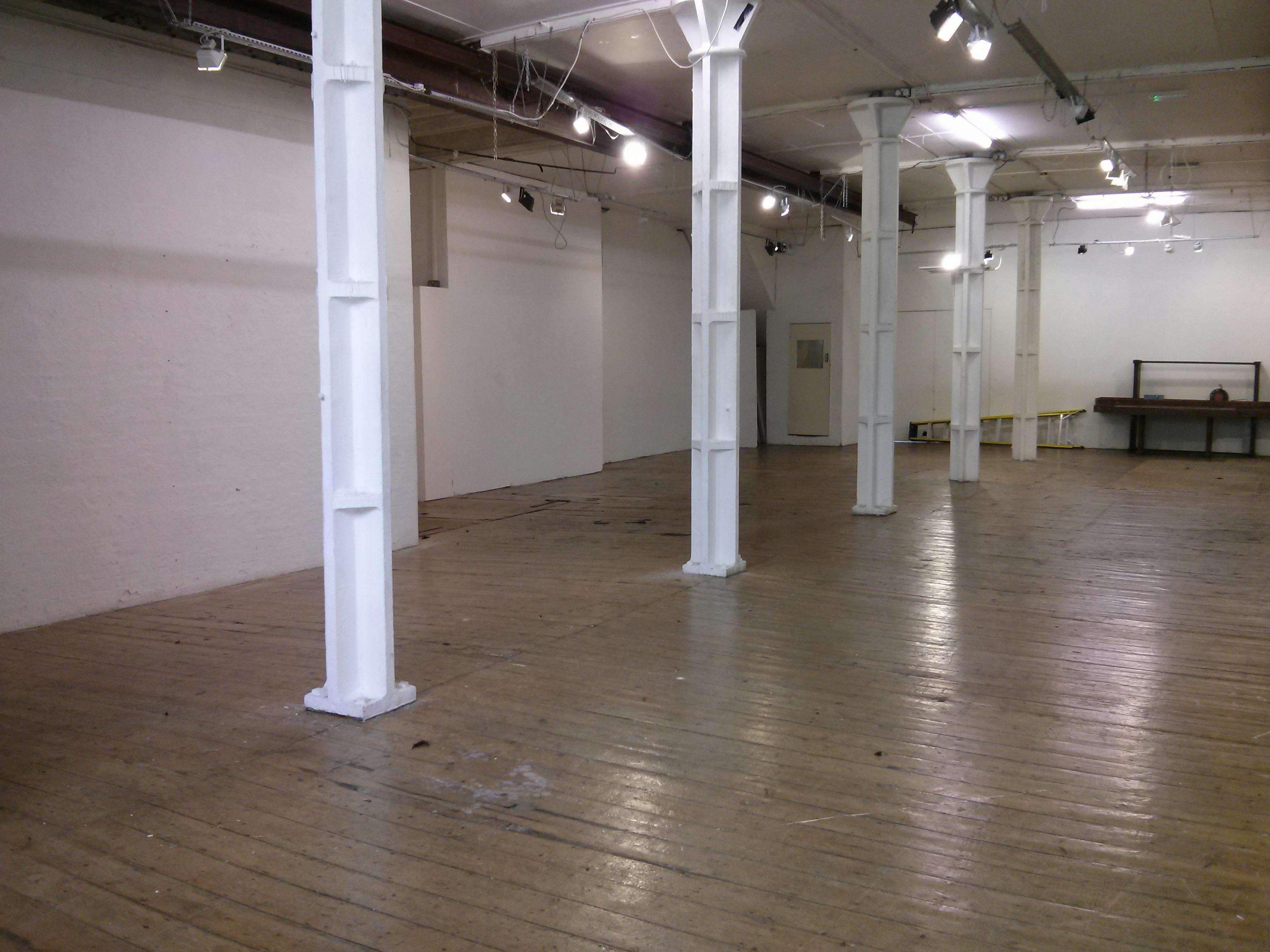 Minimalist event venue with hardwood floors at Candid Arts Trust for networking and workshops.