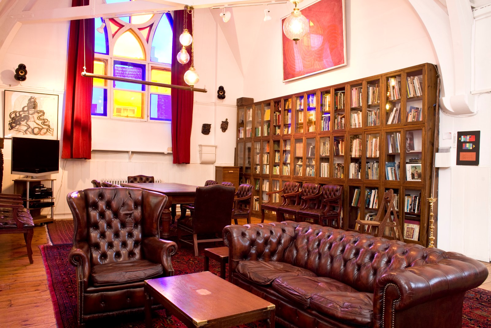 Cozy Club Room with leather seating and stained glass for workshops and gatherings.
