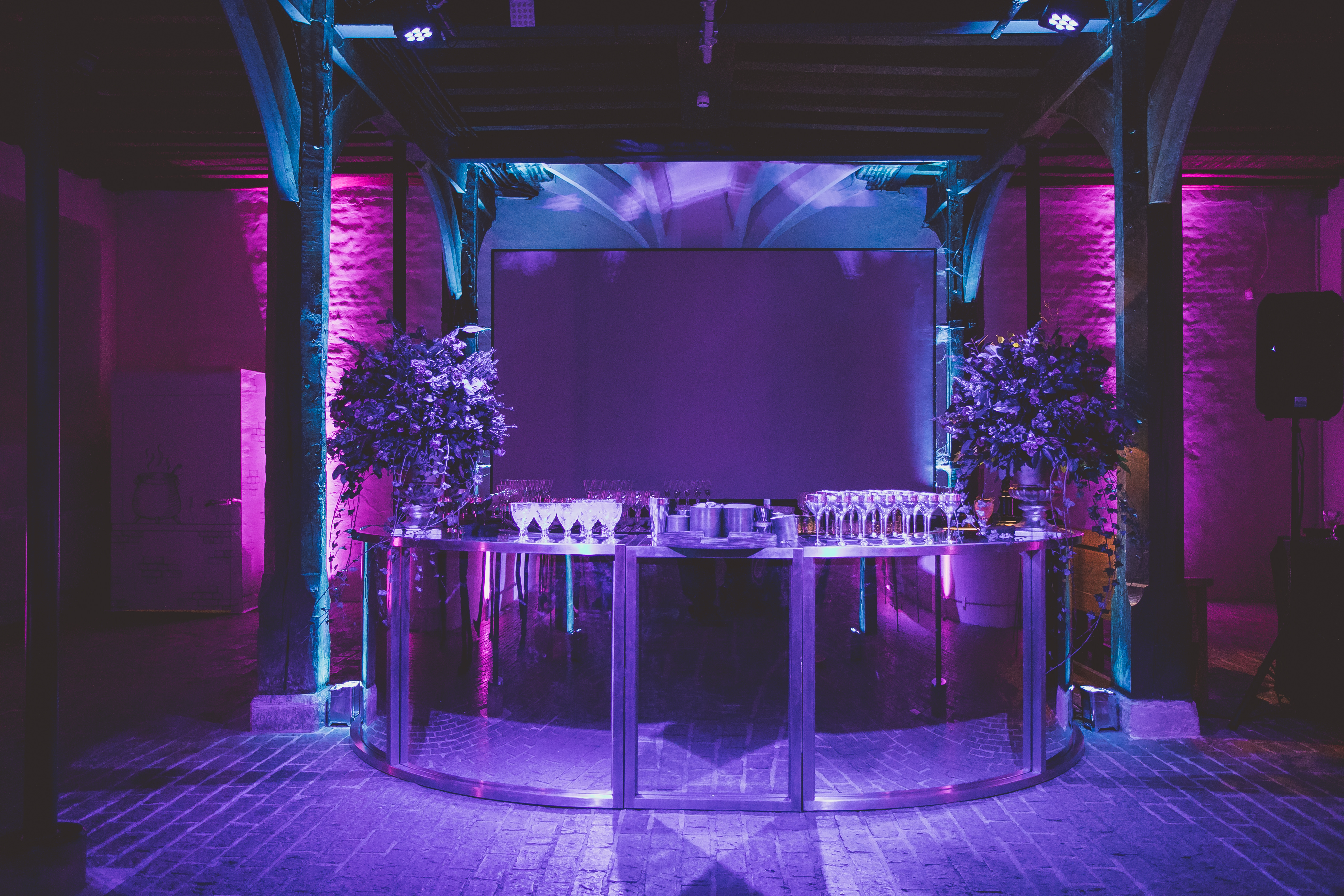 Stylish event space at Hampton Court Palace with sleek bar and vibrant lighting.
