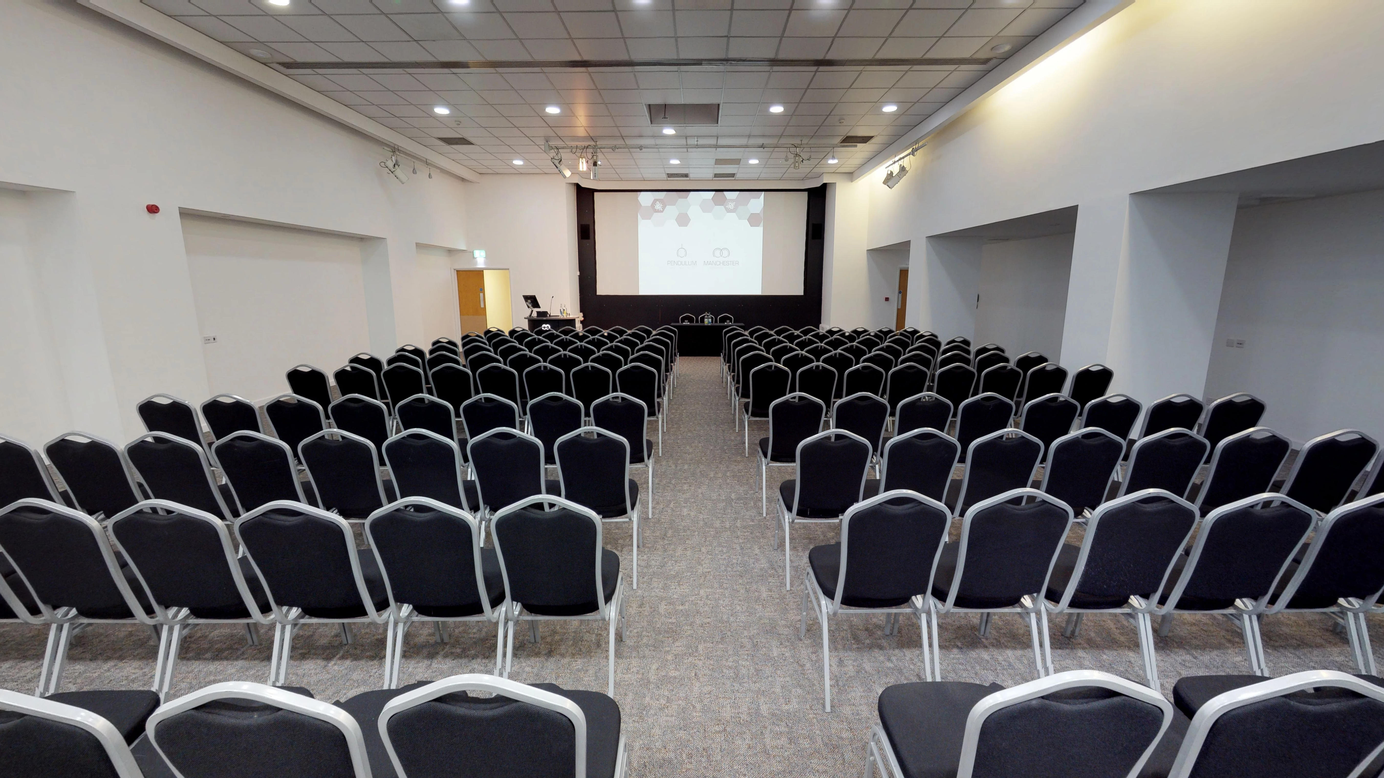 Pendulum Suite conference room with black chairs and presentation screen, ideal for events.