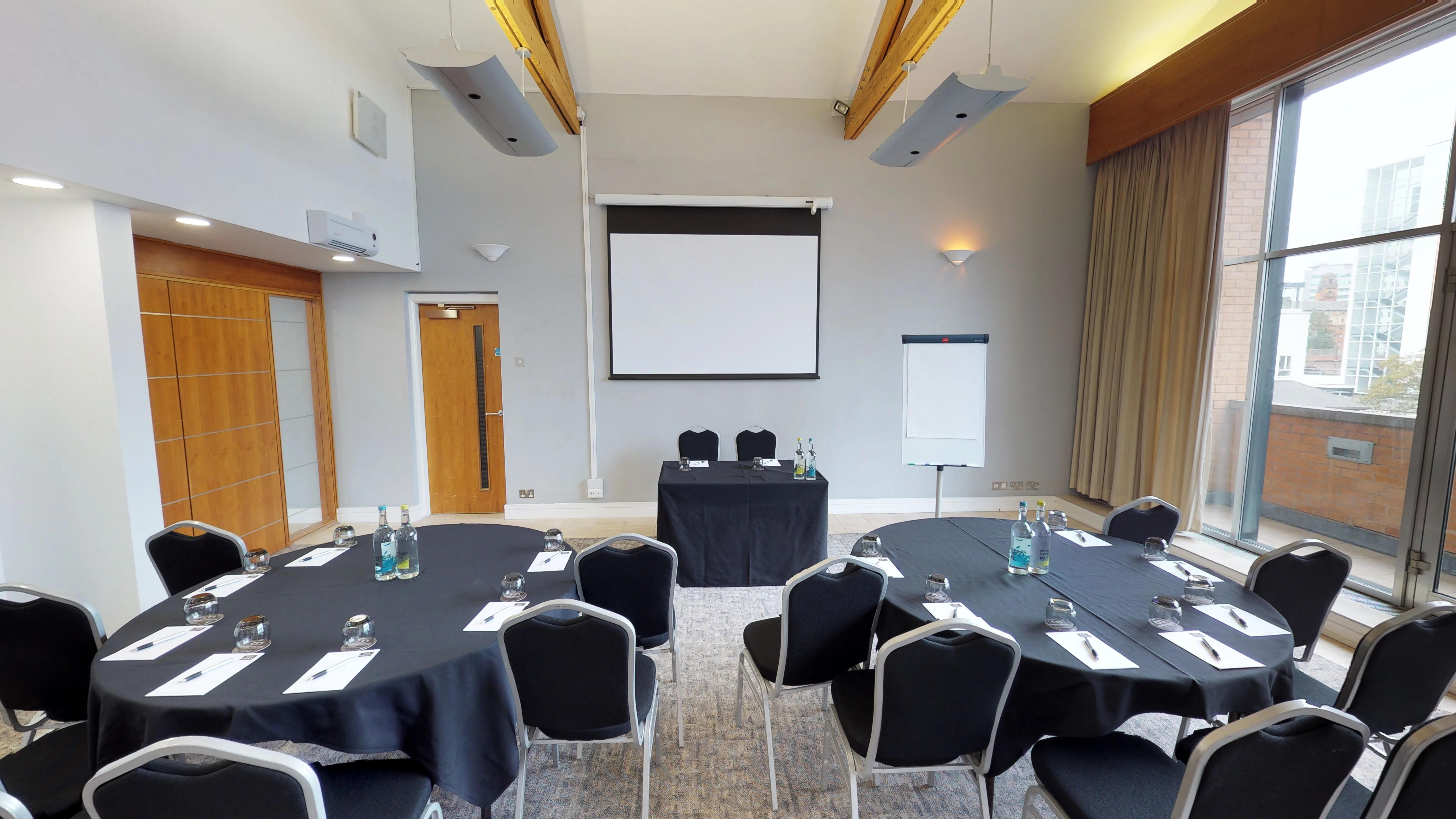 Edgerton Suite meeting room with round tables, ideal for workshops and conferences.