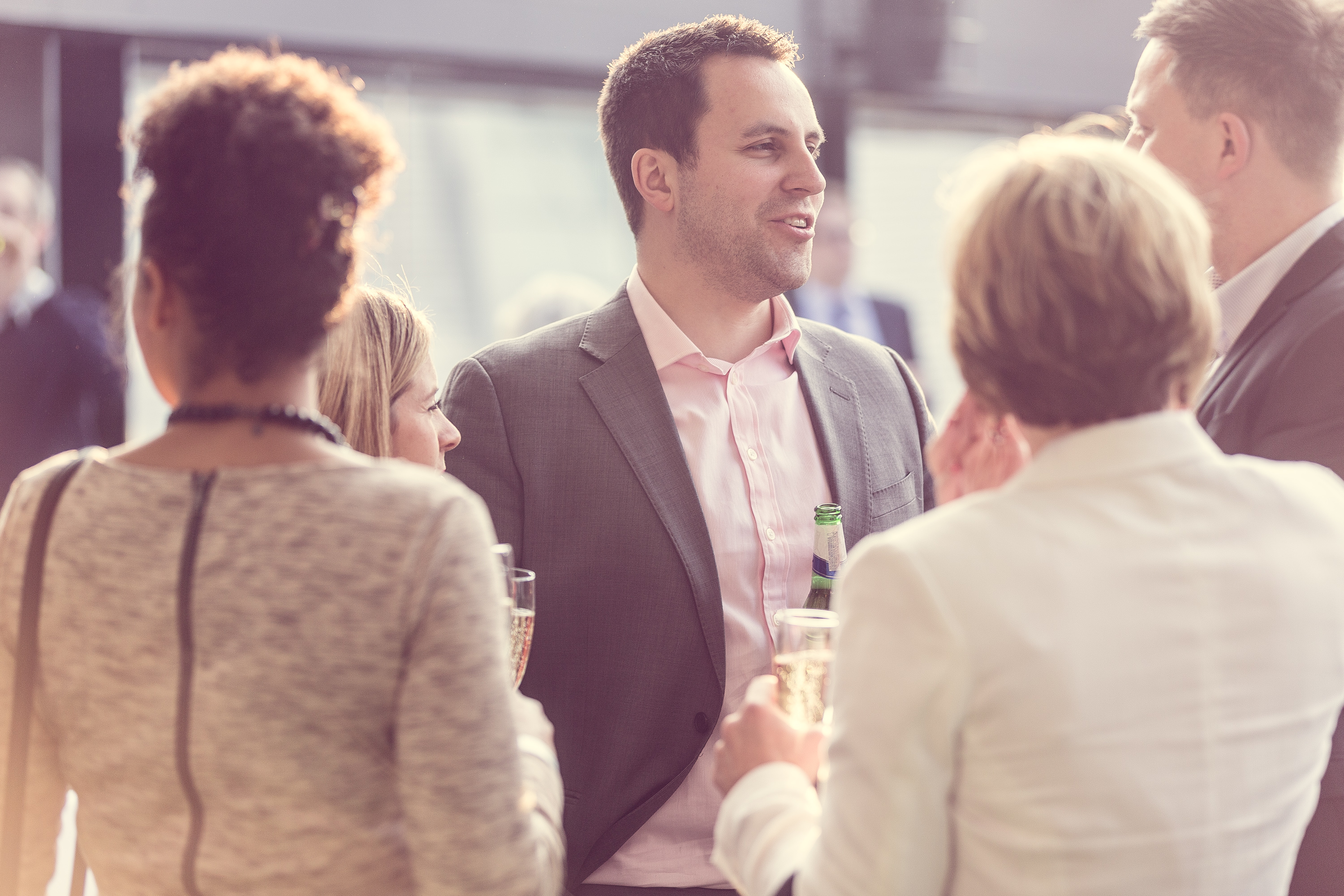 Networking event at Hotel Football with attendees in professional attire, drinks in hand.
