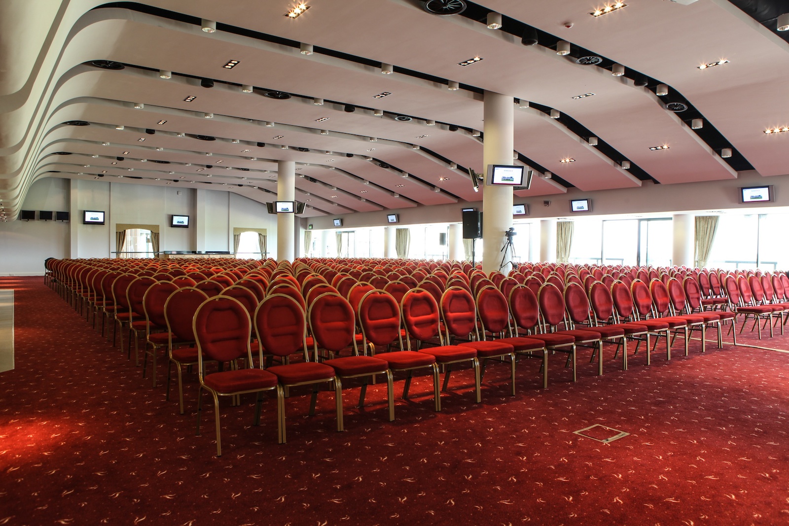 Sunloch Suite at Aintree Racecourse, spacious venue for conferences with red chairs.