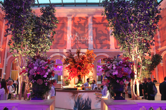 Elegant event space in The Wallace Collection with floral arrangements and ambient lighting.